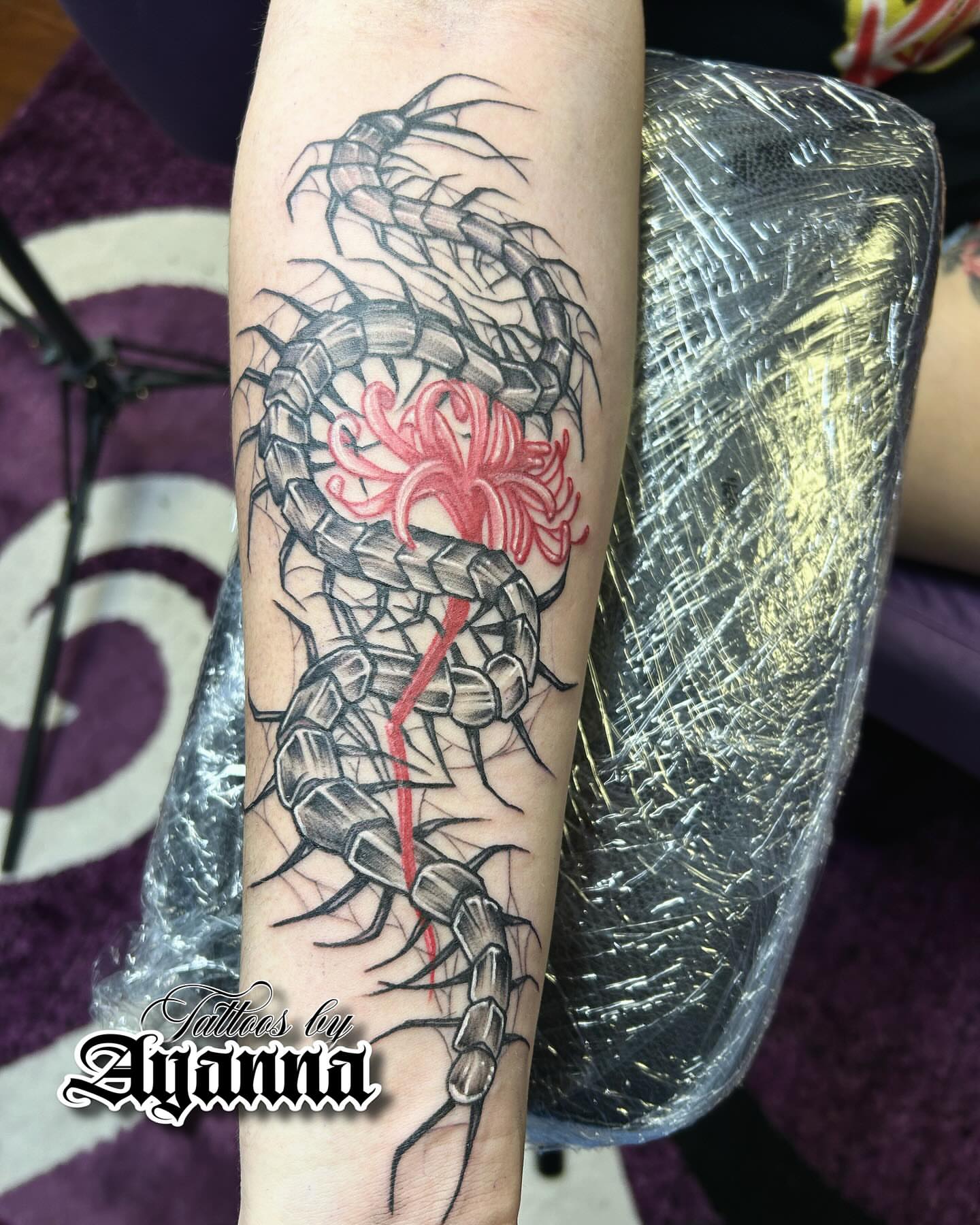 Centipede and chrysanthemum realism tattoo on the forearm by Ayanna Luna