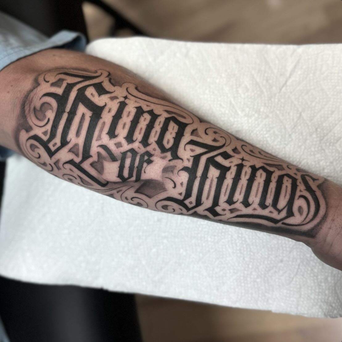 Two of Swords lettering script tattoo on the forearm by Jake Fujimura