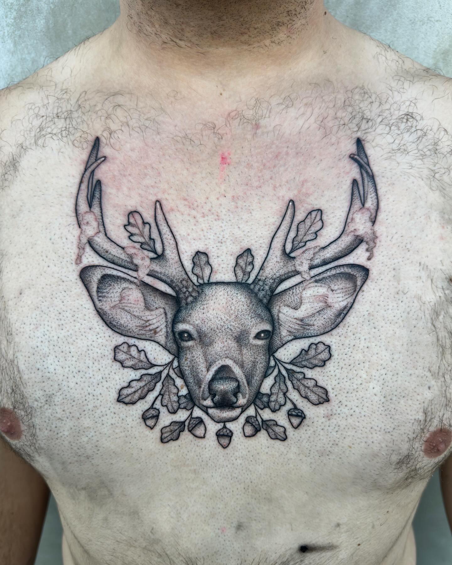 Deer head dotwork tattoo on the chest by Lawrence Edwards