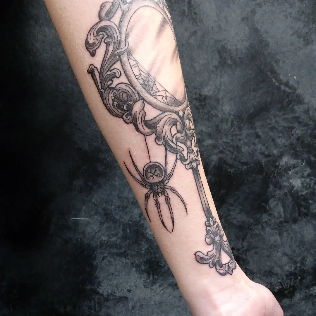 Spider and key ornamental tattoo on the forearm by Cassandra Davis