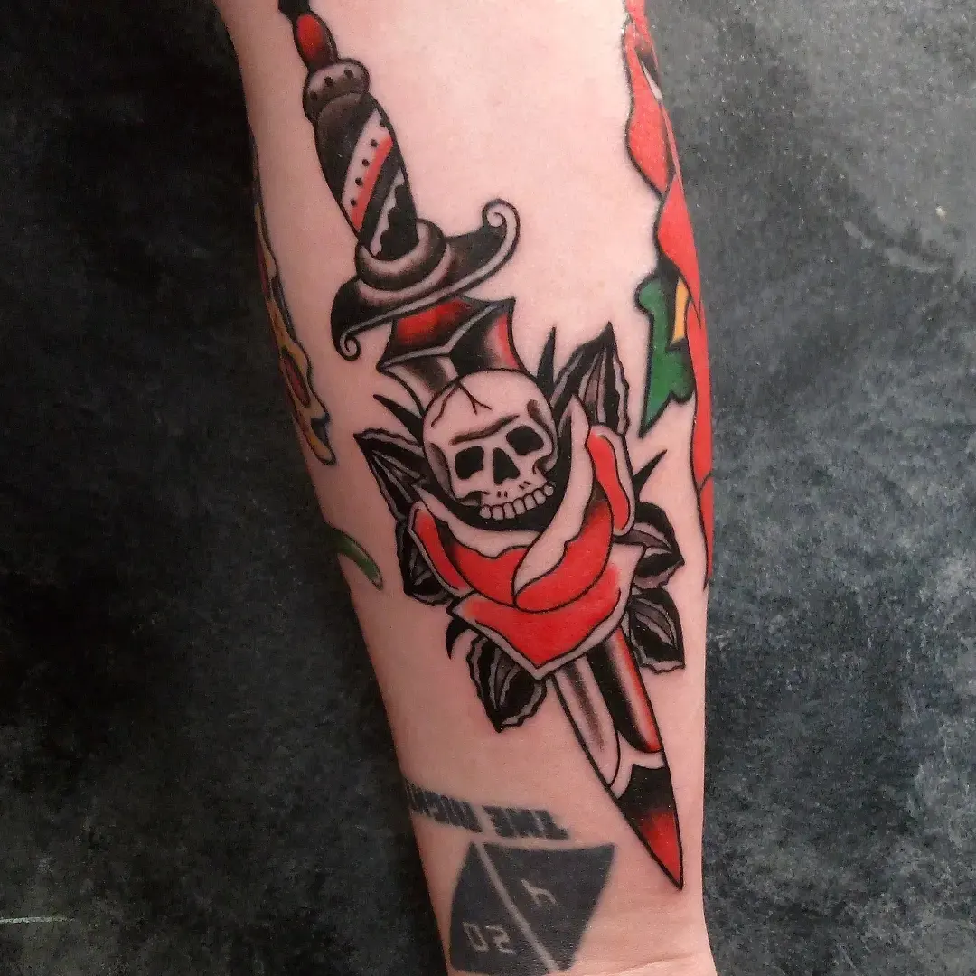 Skull and rose American traditional tattoo on the forearm by Cassandra Davis