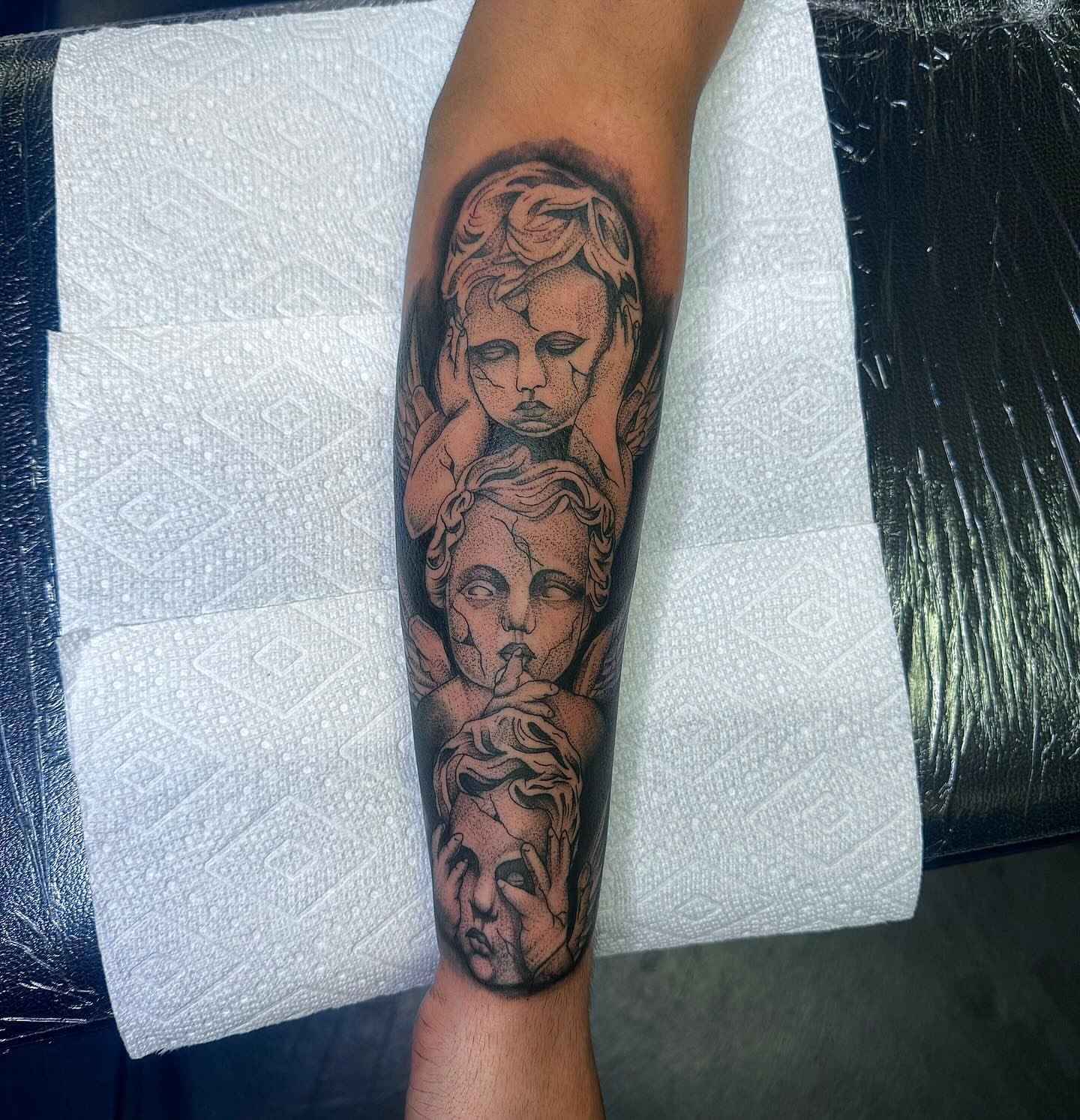 Cherubs black and grey tattoo on the forearm by Colby McClain