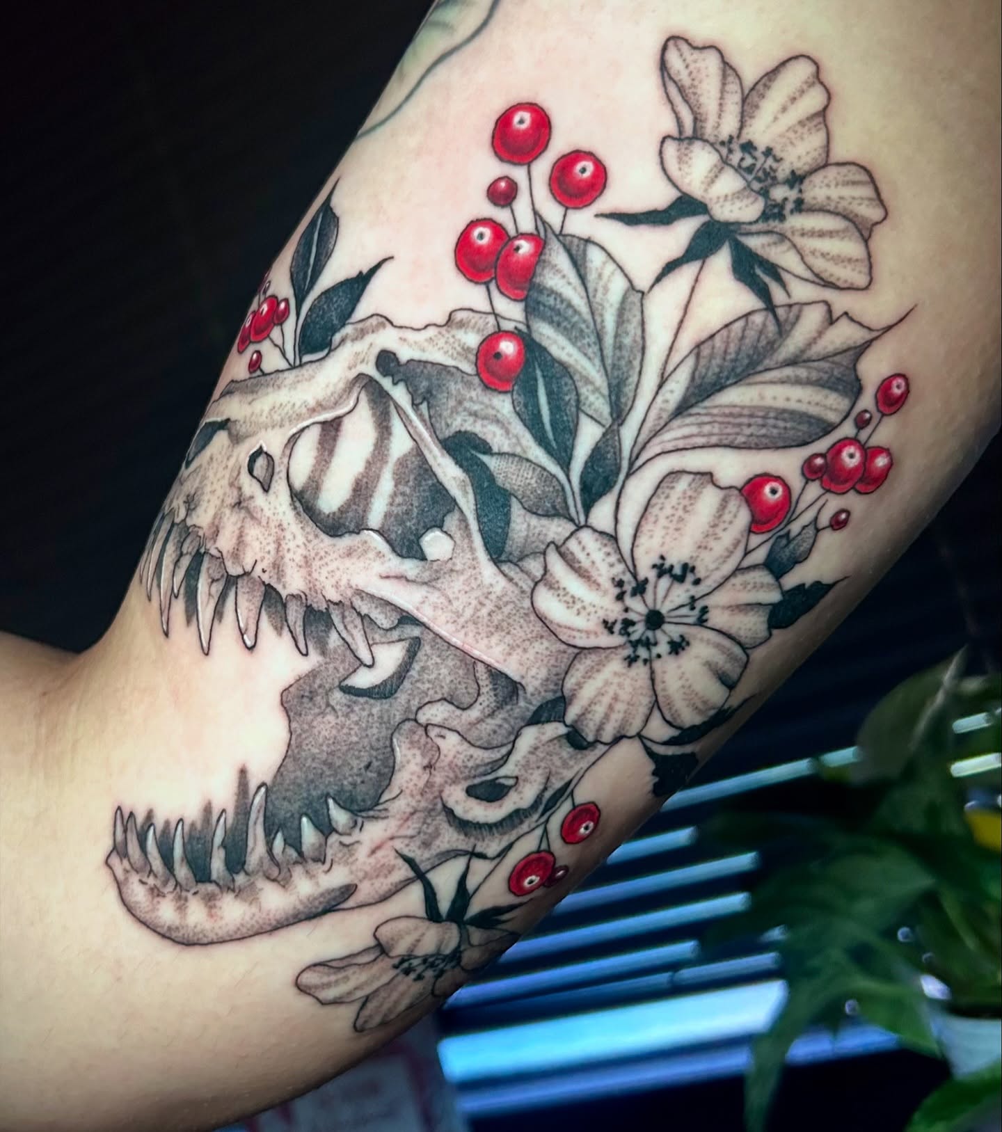 Skull and flowers realism tattoo on the forearm by Bradi