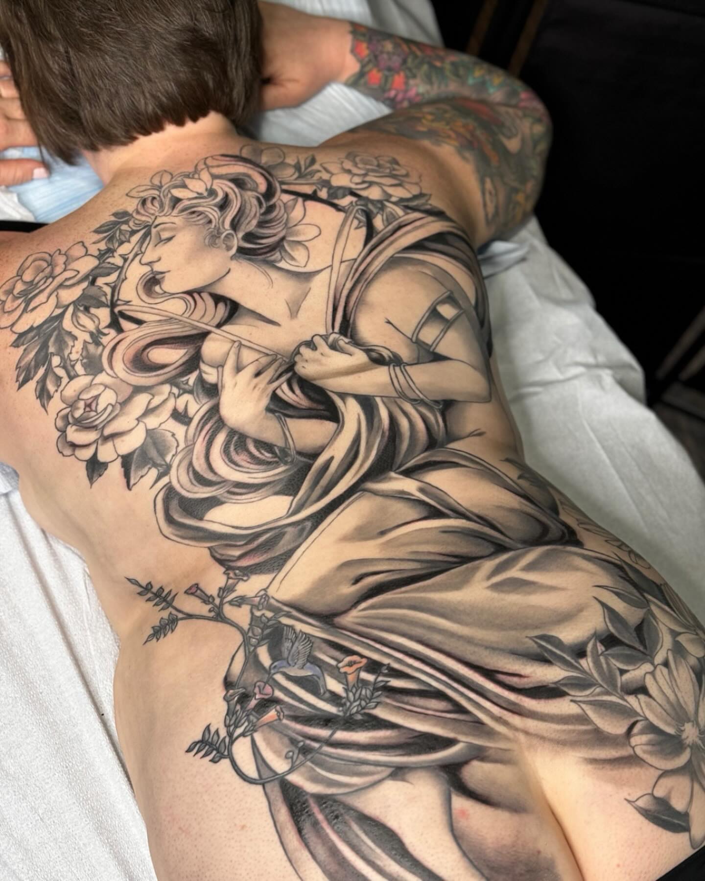 Woman with flowers realism tattoo on the back by Sam Fortney, Columbus, Ohio