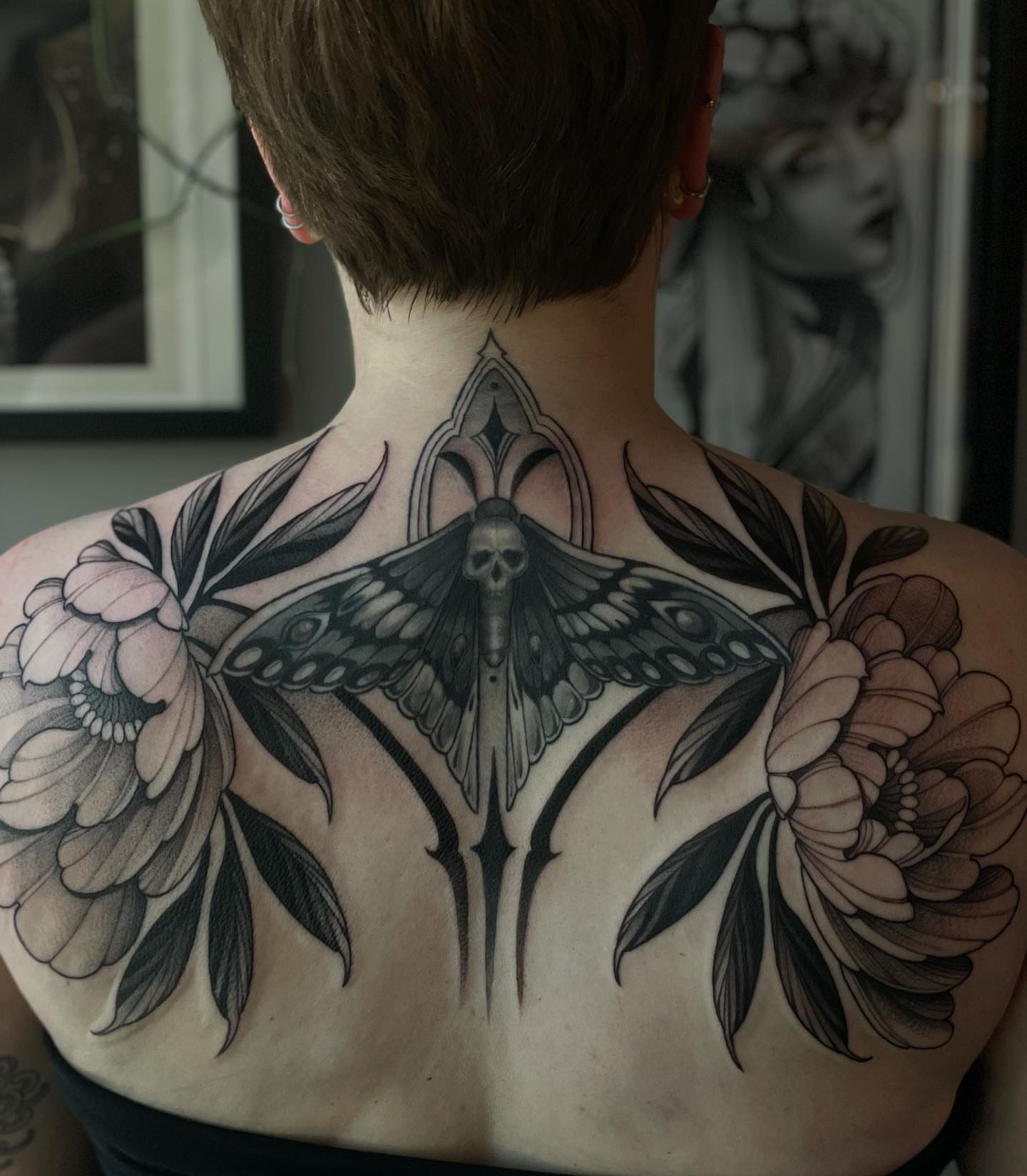 Moth and flowers realism tattoo on the back by Madelyn Roberts, Bellingham, Washington
