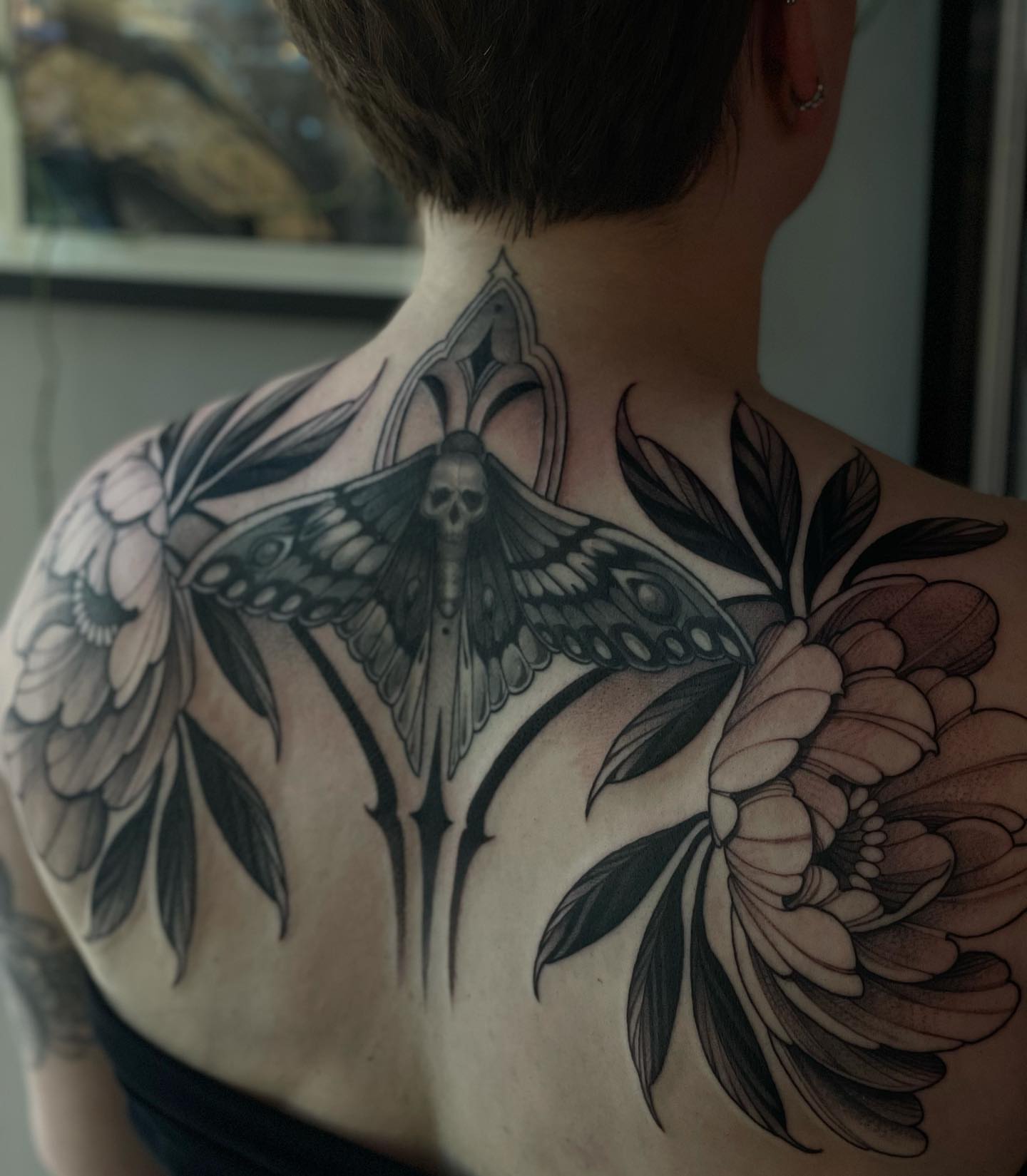 Moth and flowers realism tattoo on the back by Madelyn Roberts, Bellingham, Washington