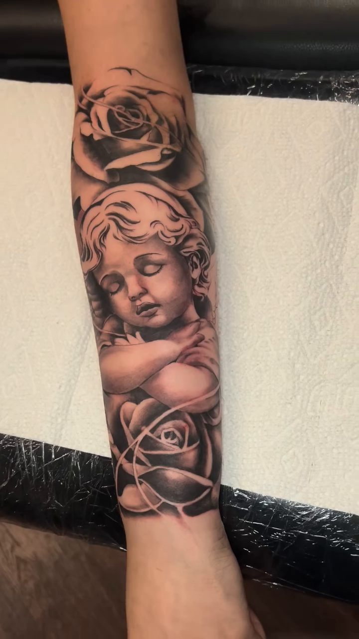 Cherub and roses realism tattoo by Moose