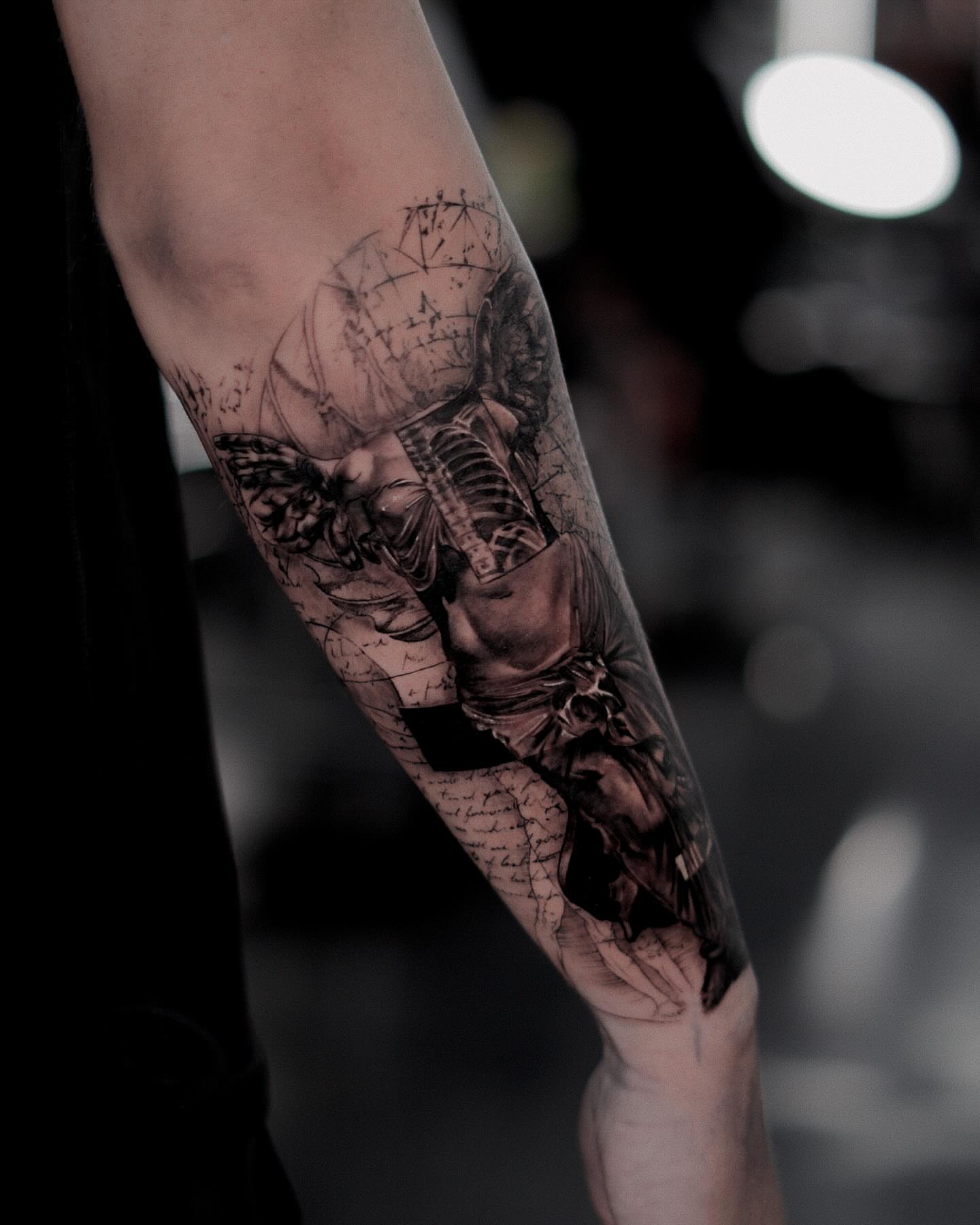 Human figure with mechanical elements realism tattoo on the forearm by Ron Alvarez