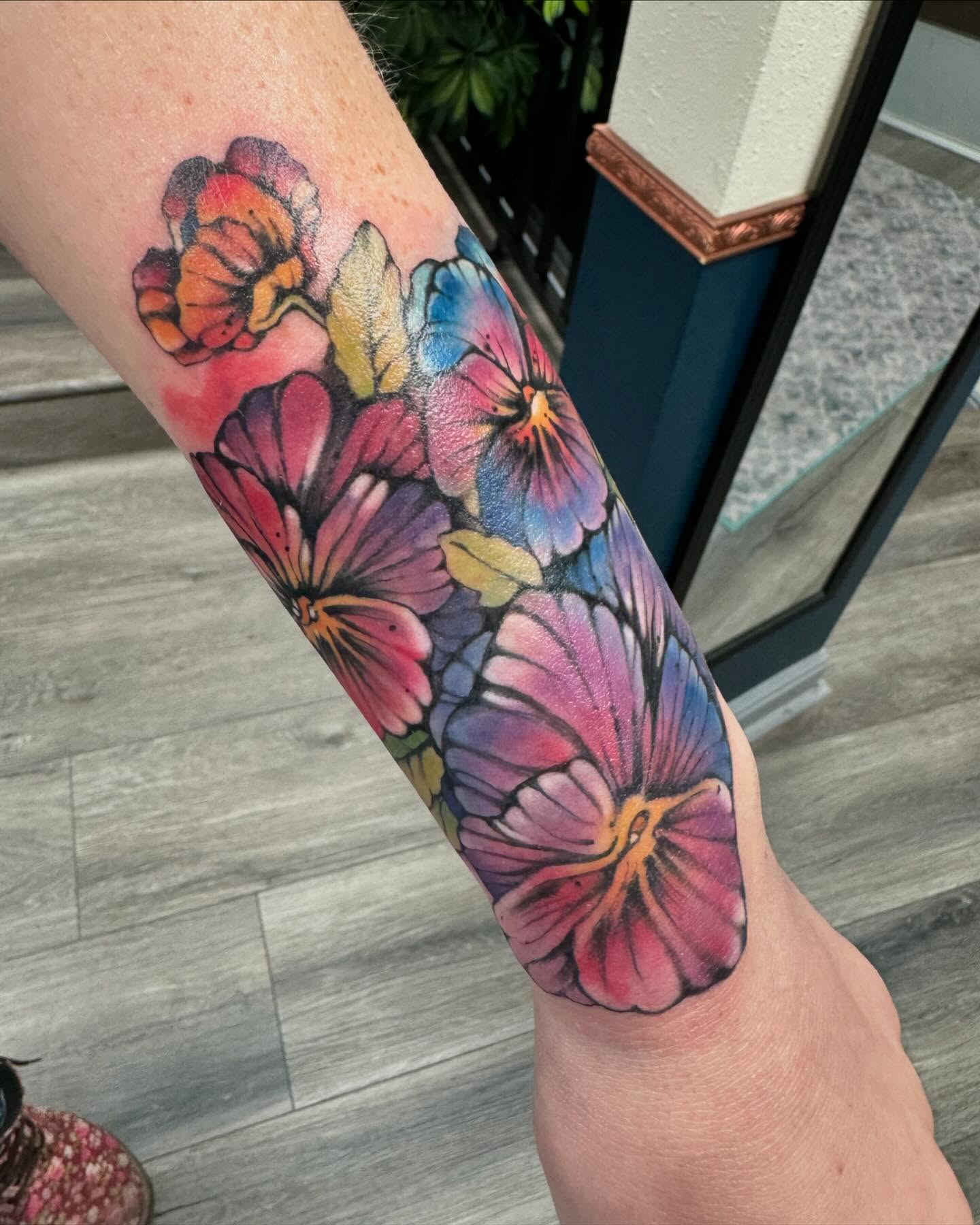 Pansies watercolor tattoo on the forearm by Robyn Mahon