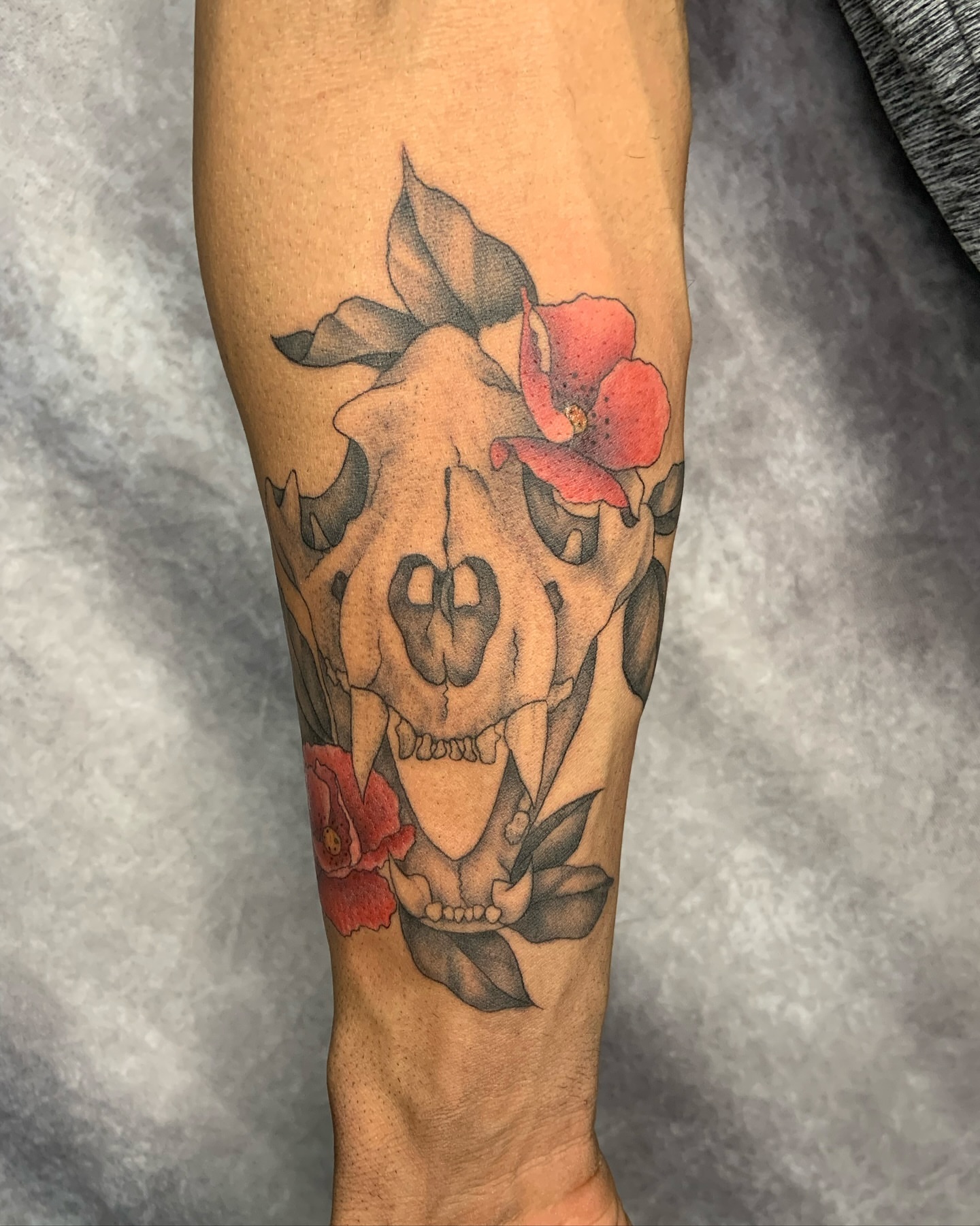 Skull with flowers black and grey tattoo on the forearm by Vanessa Kendyll’s Tattoos