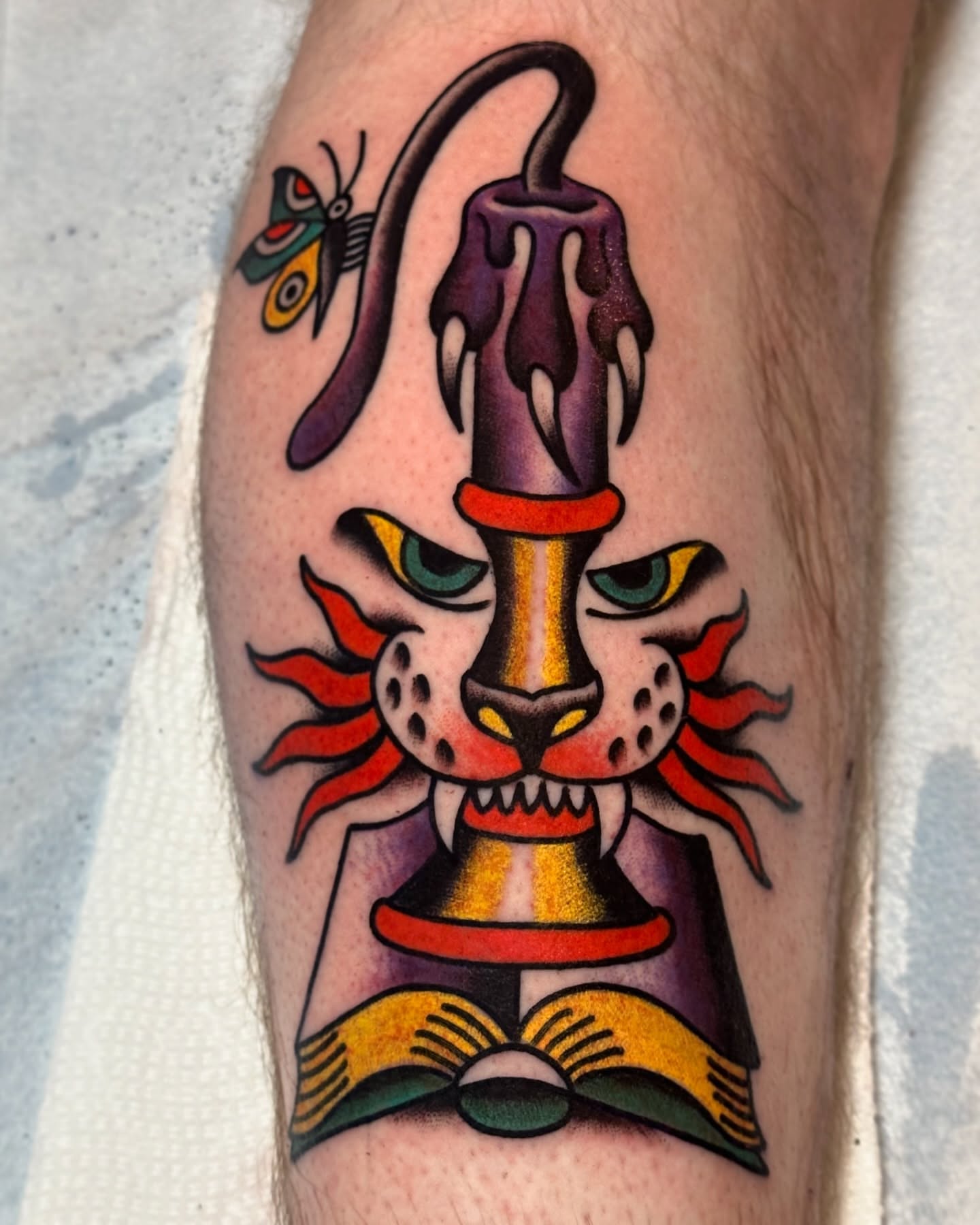 Cat head with candle American traditional tattoo on the forearm by Britney Goodman
