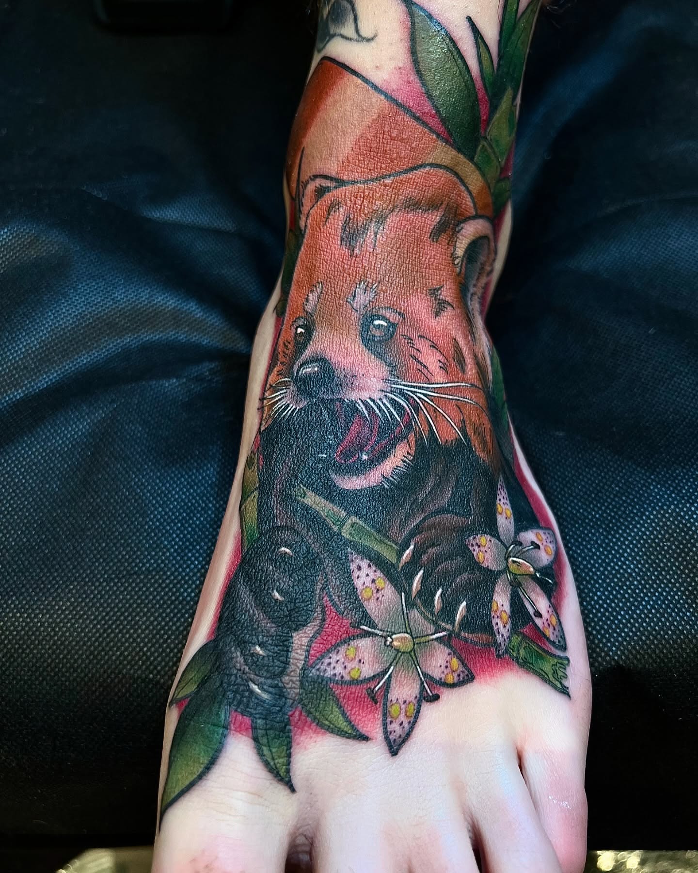 Red panda and flowers American traditional tattoo on the foot by Pam Sanders