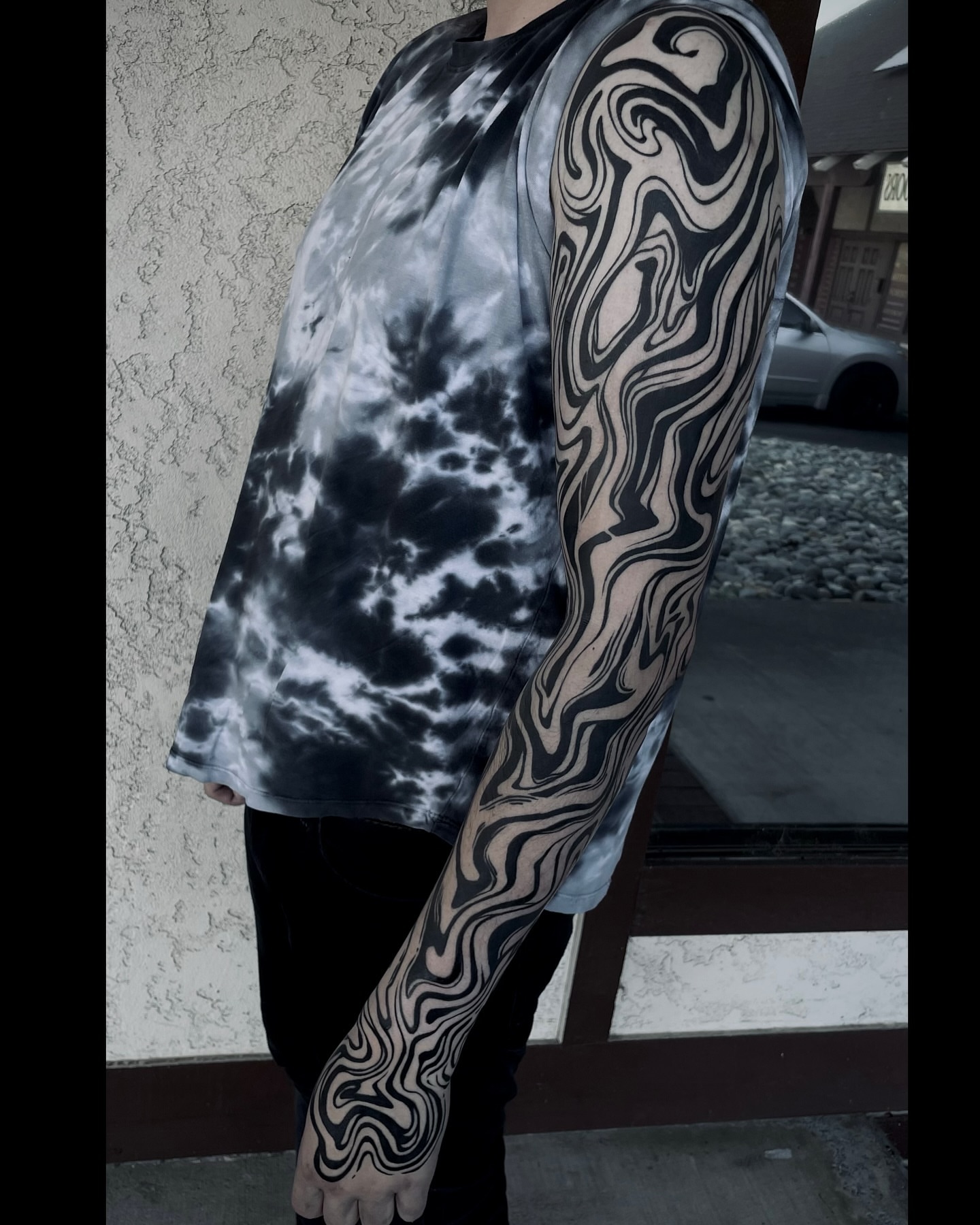 Abstract wave pattern black and grey tattoo on the upper arm by Frank Mostek