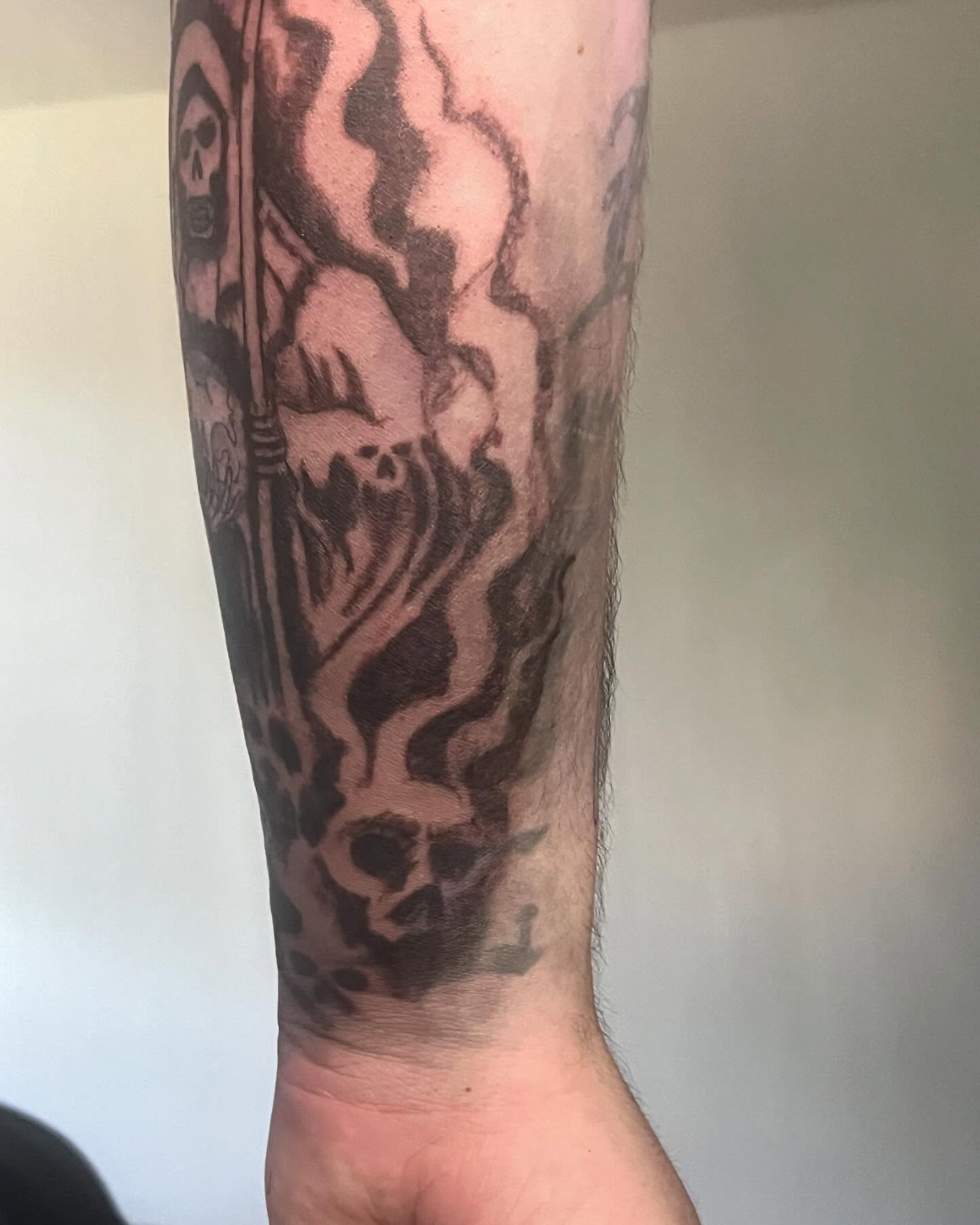 Skull and flames black and grey tattoo on the forearm by Ink_ Hustle36