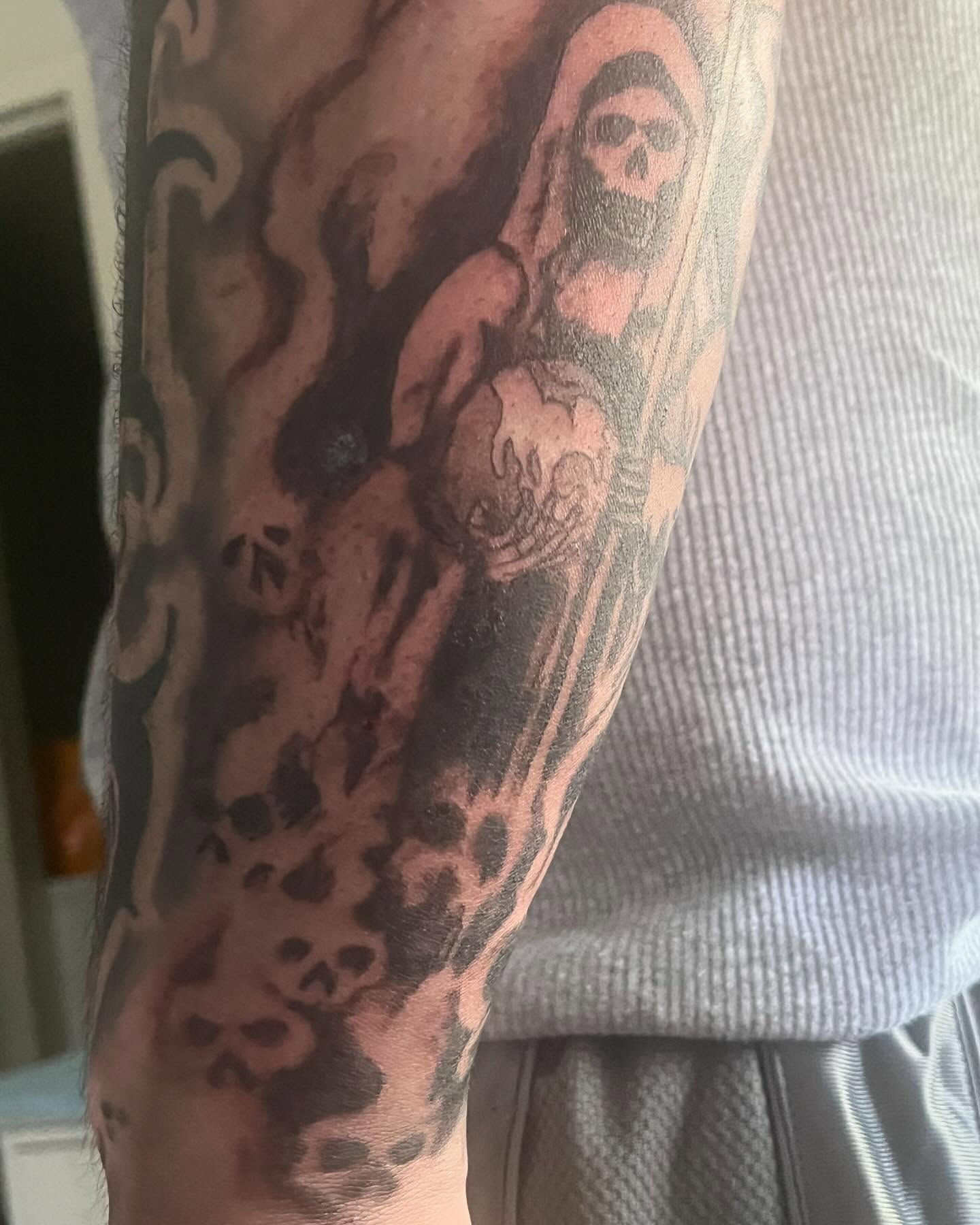 Skulls and flames trash polka tattoo on the forearm by Ink_ Hustle36