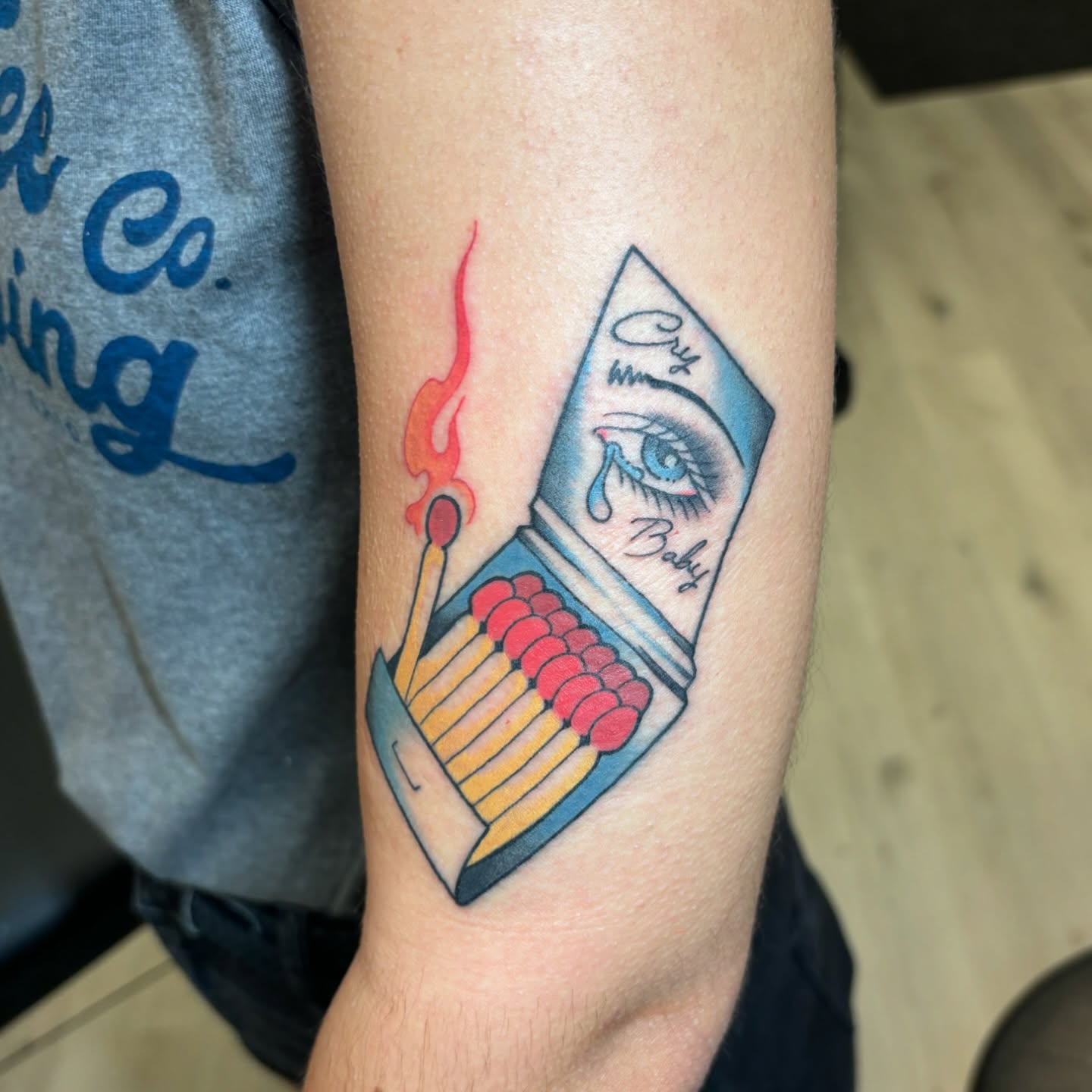 Matchbox with crying eye new school tattoo on the forearm by Jordan Wray