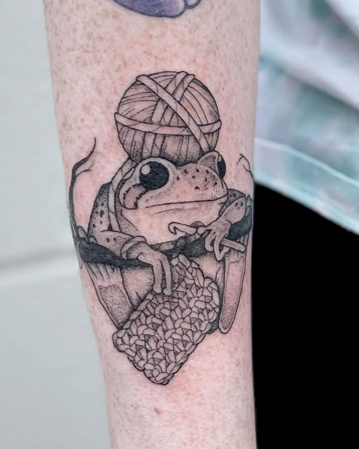 Frog black and grey tattoo on the forearm by Katie Stacy