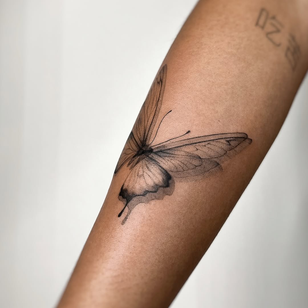 Butterfly fine line tattoo on the forearm by tattoo artist