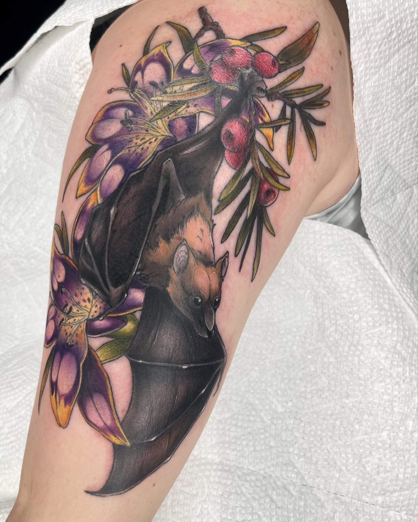 Bat and flowers realism tattoo on the forearm by Lexx Christine