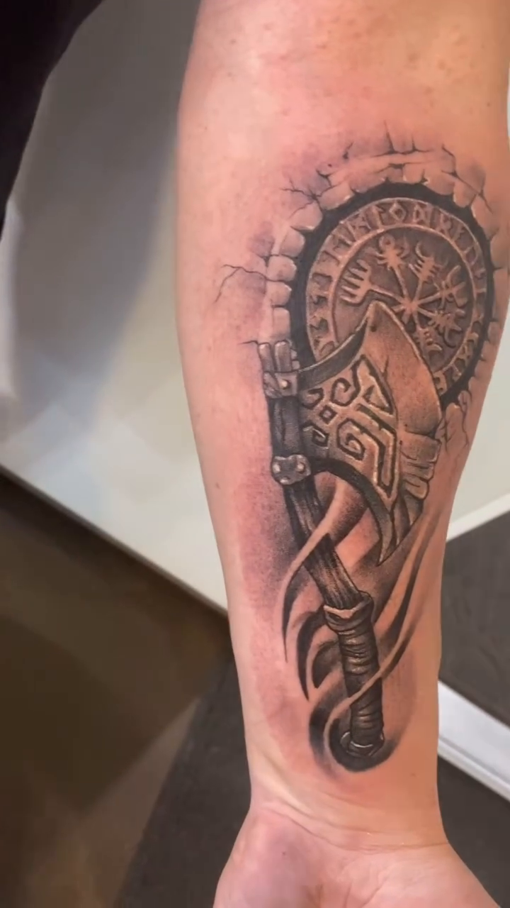 Viking axe and compass realism tattoo on the forearm by Cody Wolfe