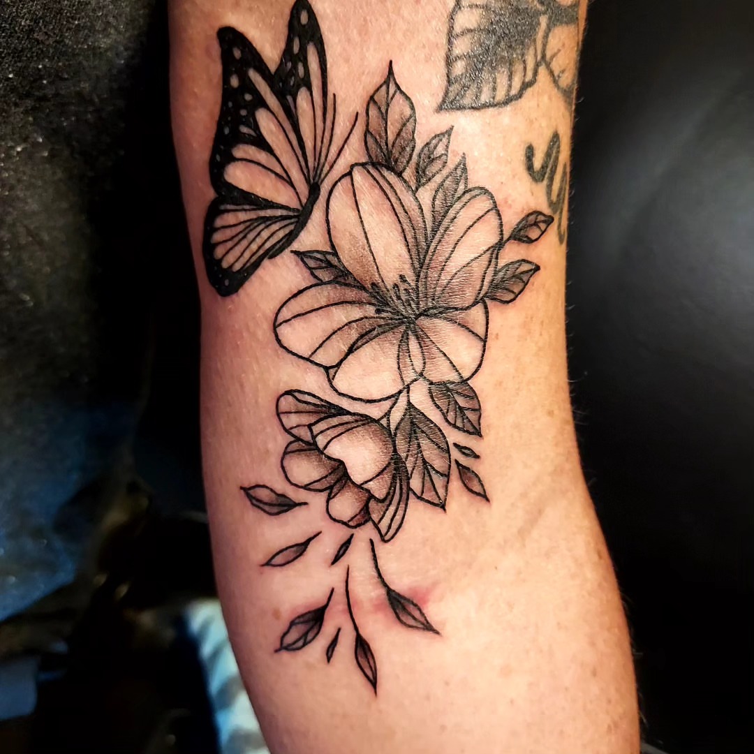 Flowers and butterfly black and grey tattoo on the forearm by Dave Johnson, Billings, Montana