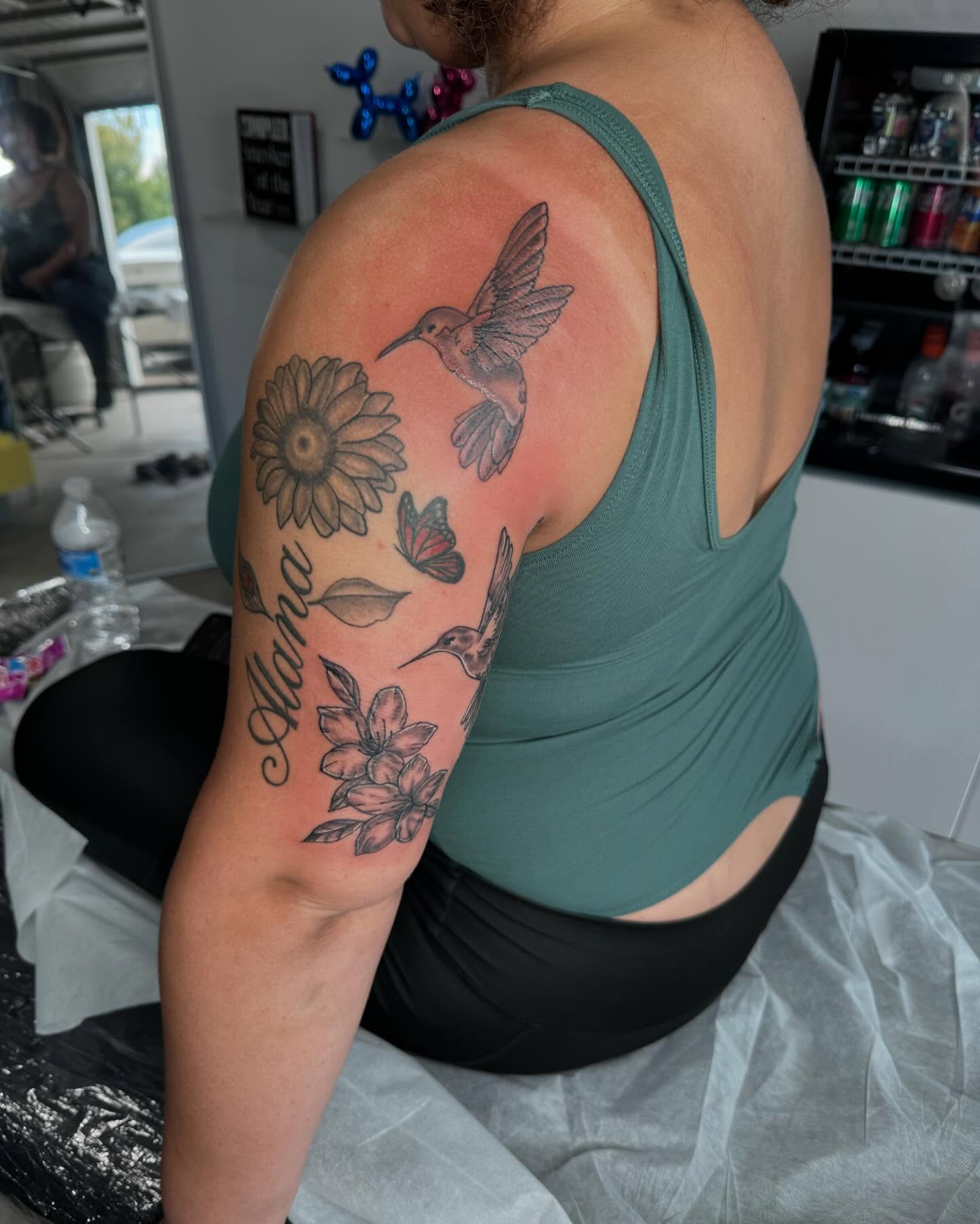 Hummingbird and flowers black and grey tattoo on the shoulder by Sierra 🩷