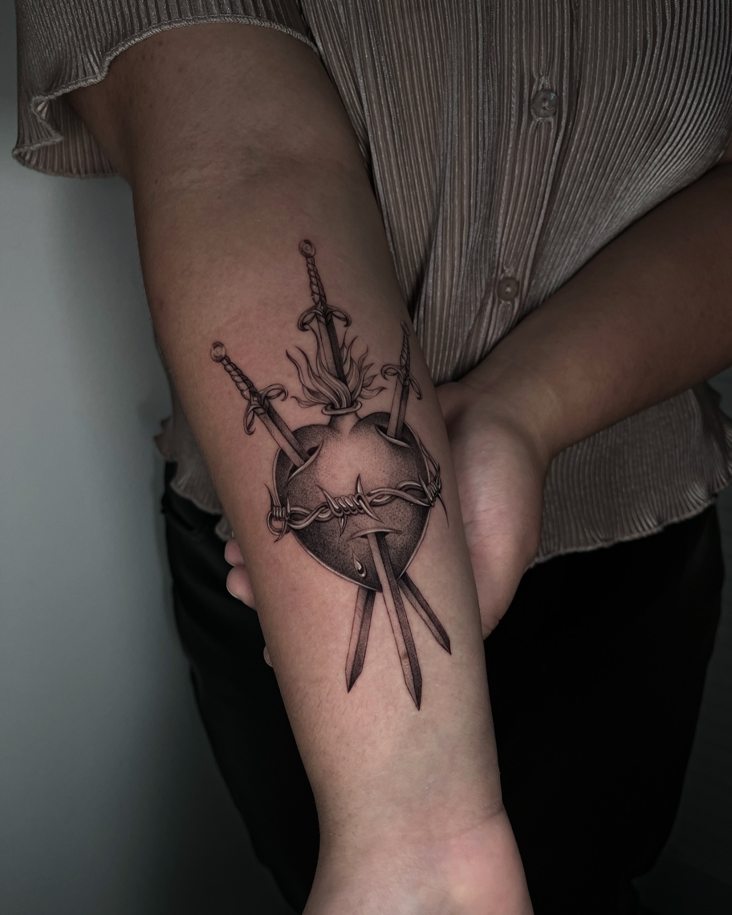 Heart with swords black and grey tattoo on the forearm by Cybersigilism & Fineline Blackwork