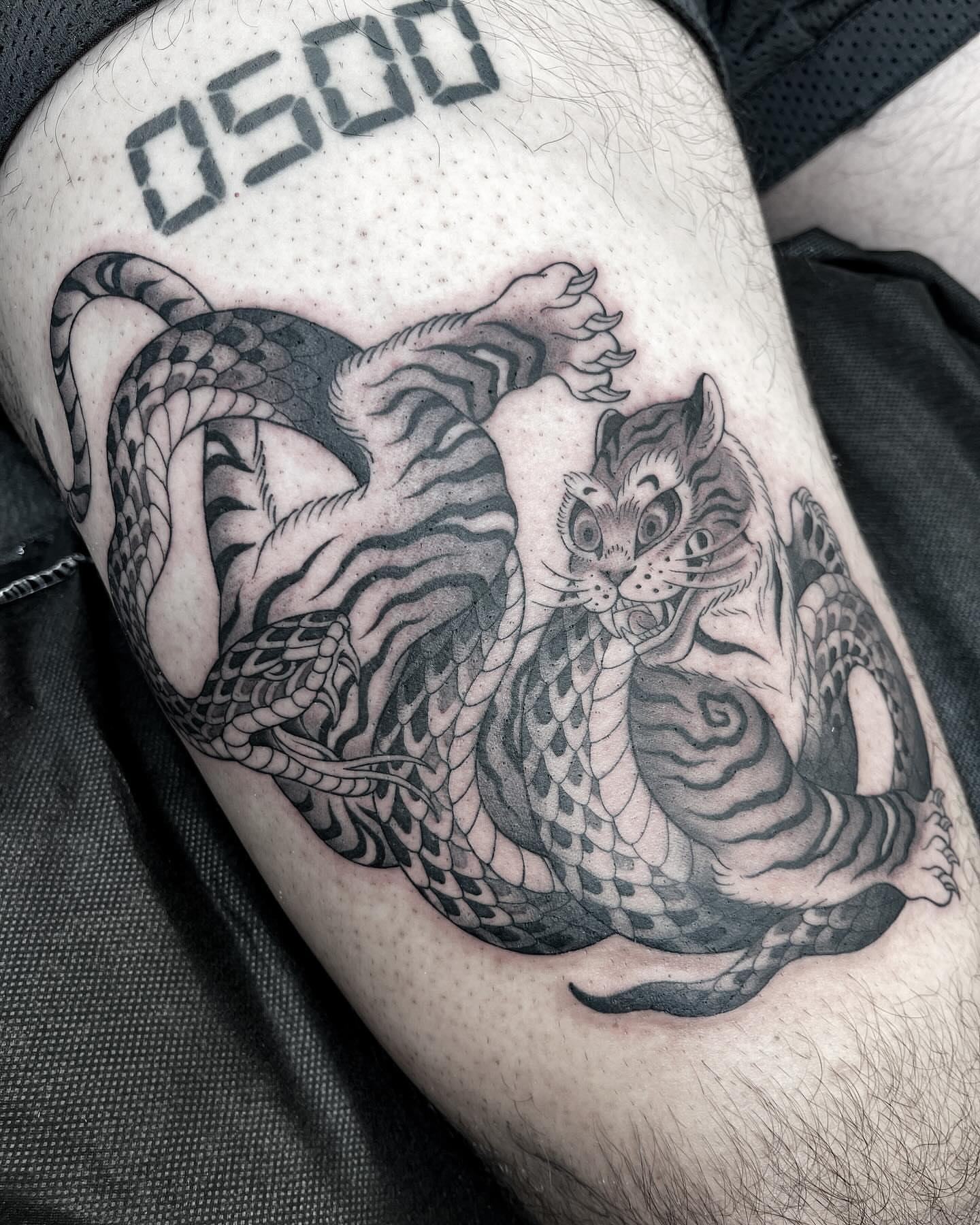 Tiger and snake realism tattoo on the thigh by Kelsi Steffensen