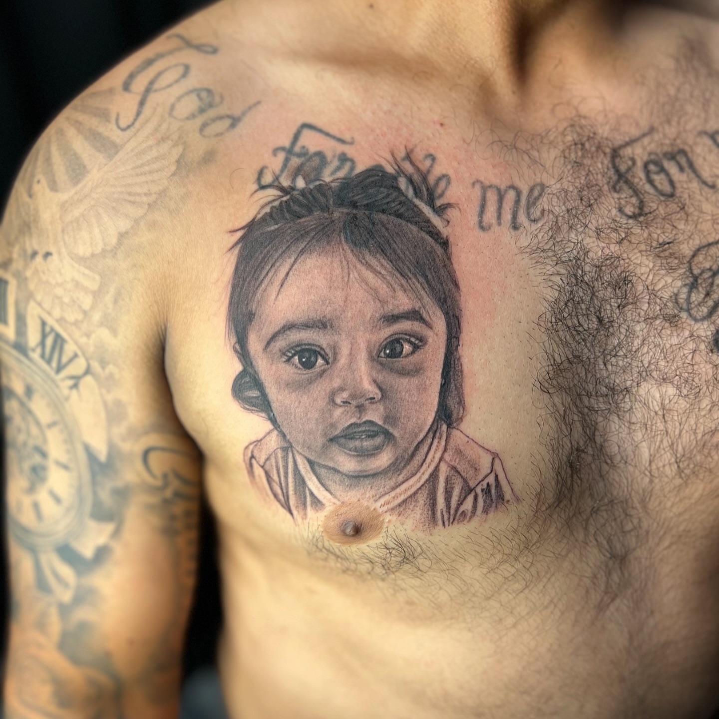 Child portrait realism tattoo on the chest by JT Ink