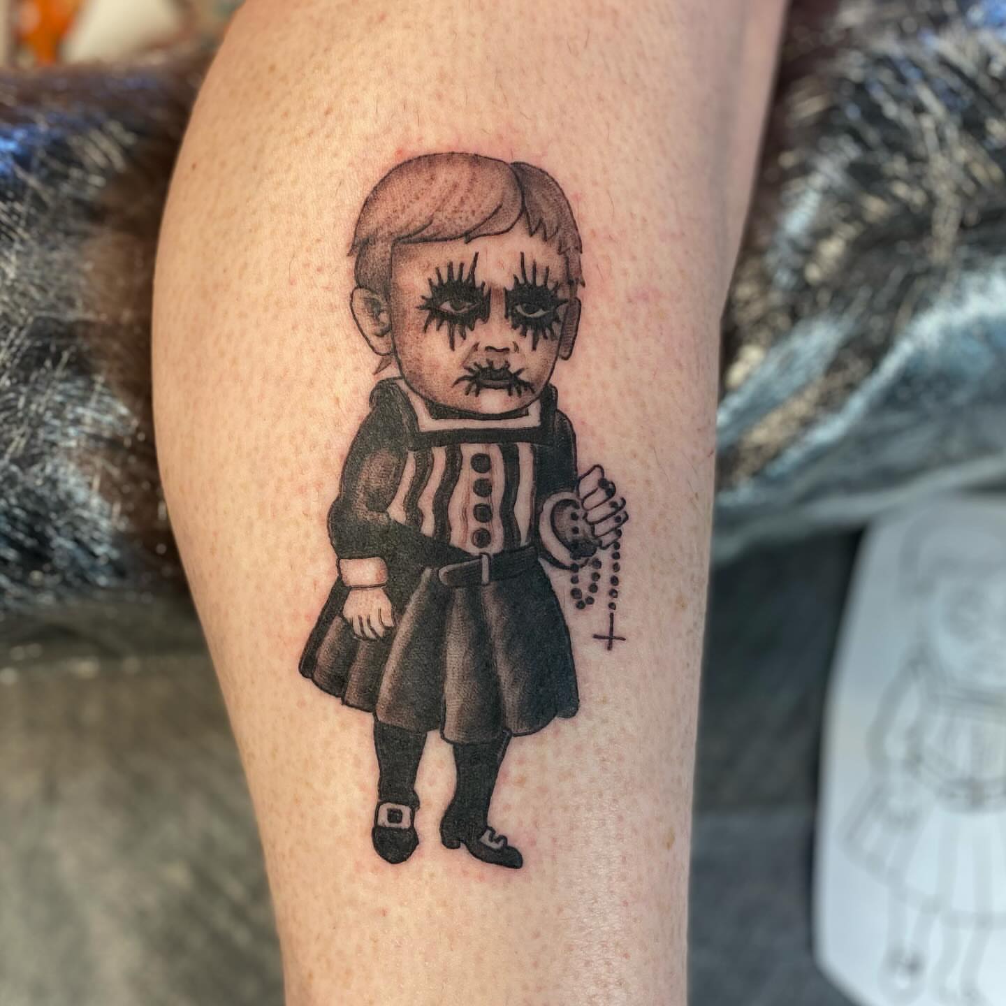 Child with rosary black and grey tattoo on the thigh by jim collins, Dayton, Ohio