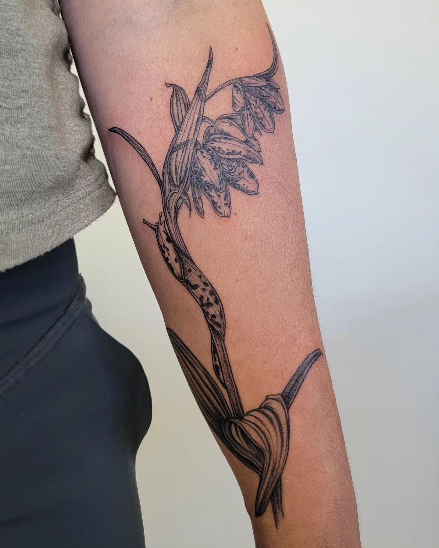 Orchid black and grey tattoo on the forearm by Sierra (cc) Klein