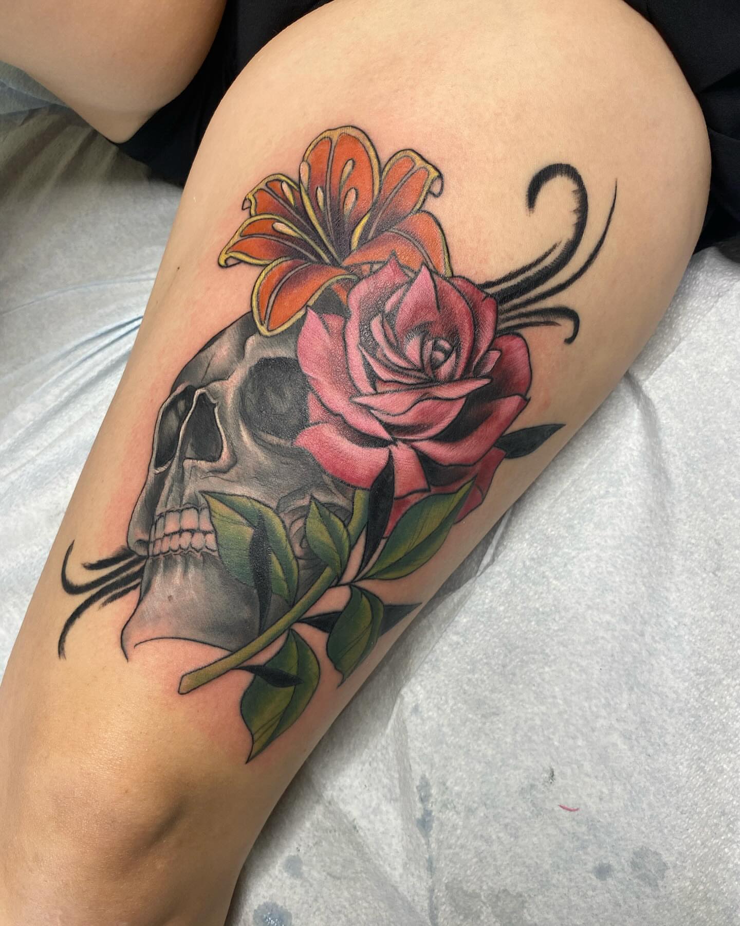 Skull and flowers realism tattoo on the thigh by Taya Lynn, Hudson, Wisconsin