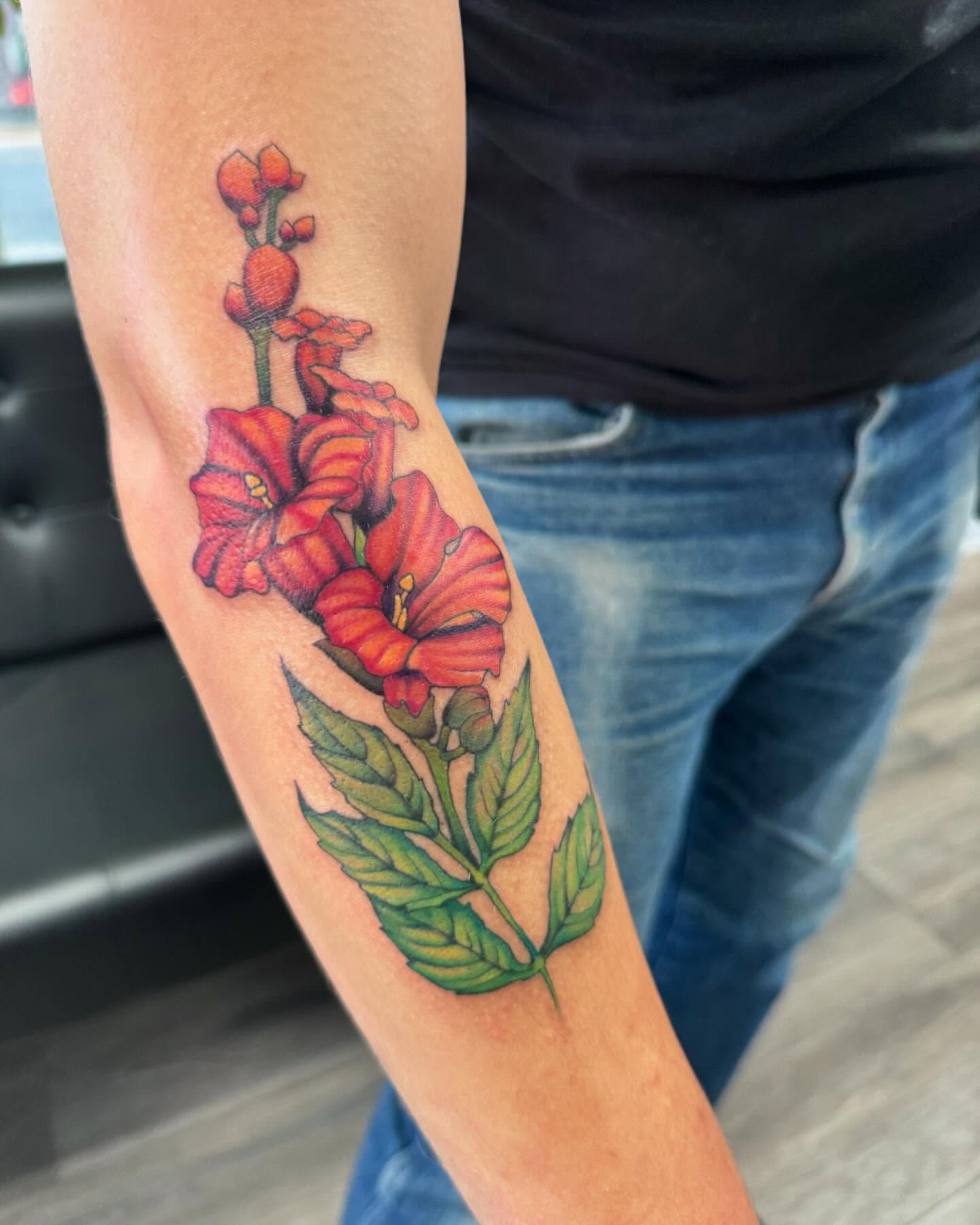 Red flowers realism tattoo on the forearm by Robyn Mahon