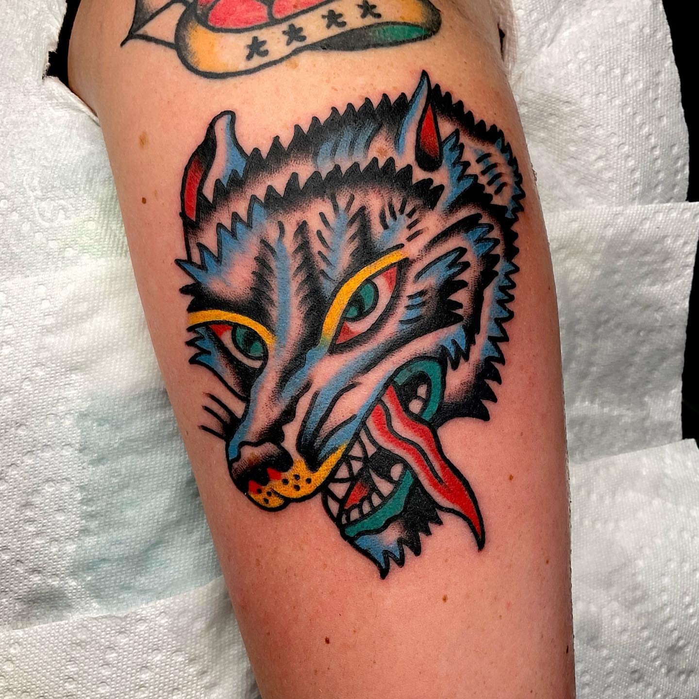 Wolf head American traditional tattoo on the forearm by Dorian Grey Baker