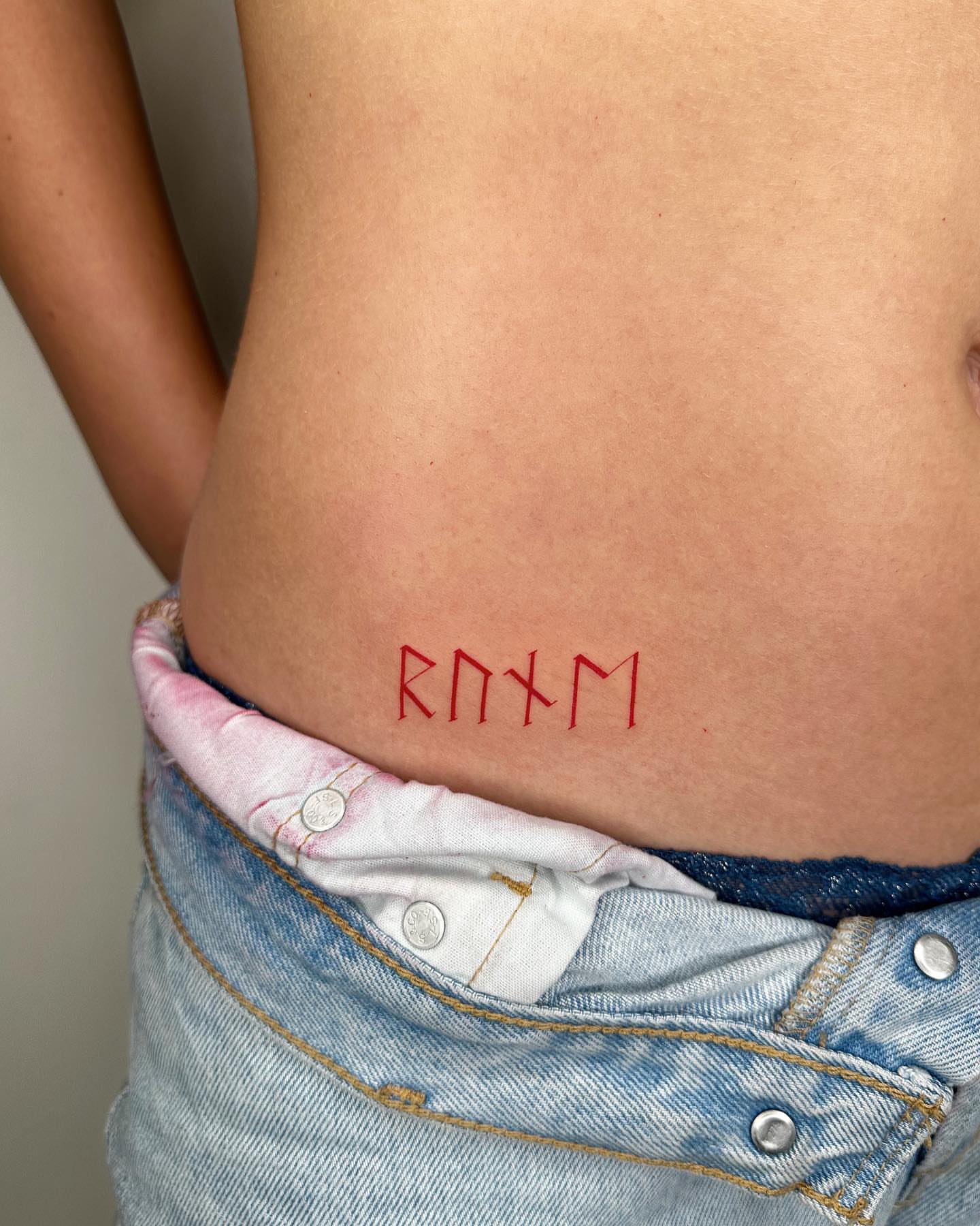 Runic script lettering script tattoo on the torso by oc fine line & tiny tattoos