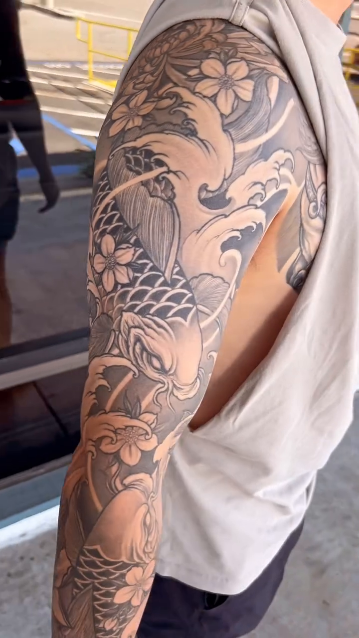 Dragon and koi sleeve with waves Japanese tattoo on the upper arm by Derek (Nghia) Chung