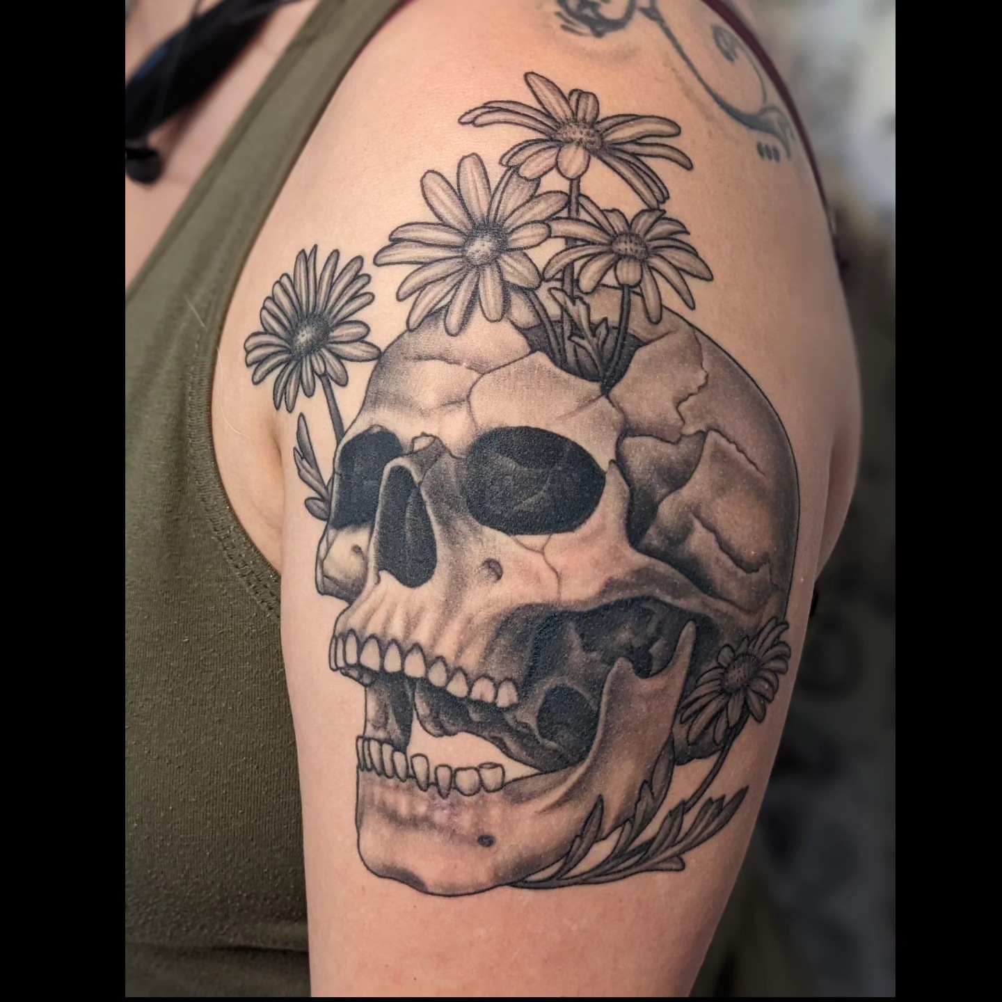 Skull with flowers realism tattoo on the shoulder by Matt Simmonds