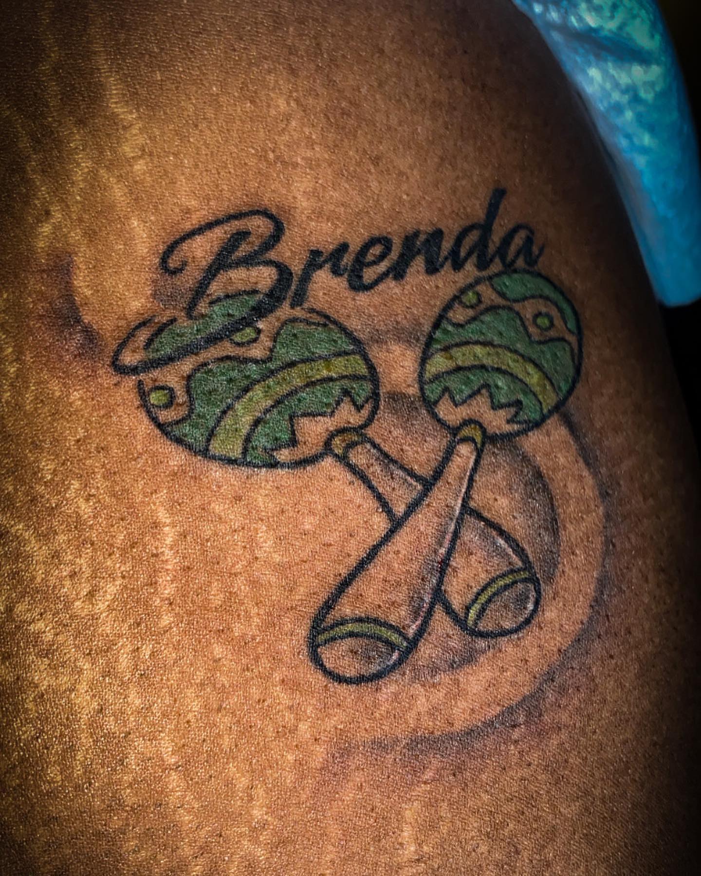 Maracas and name American traditional tattoo on the upper arm by Traveling Tattoo Artist π