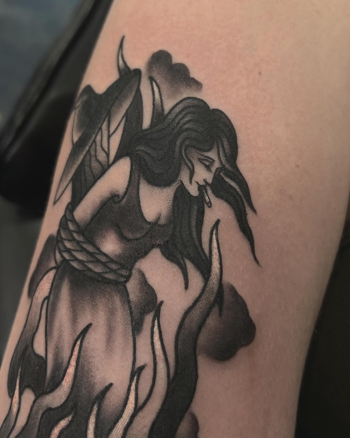 Woman in flames black and grey tattoo on the upper arm by Samantha C, Bremerton, Washington