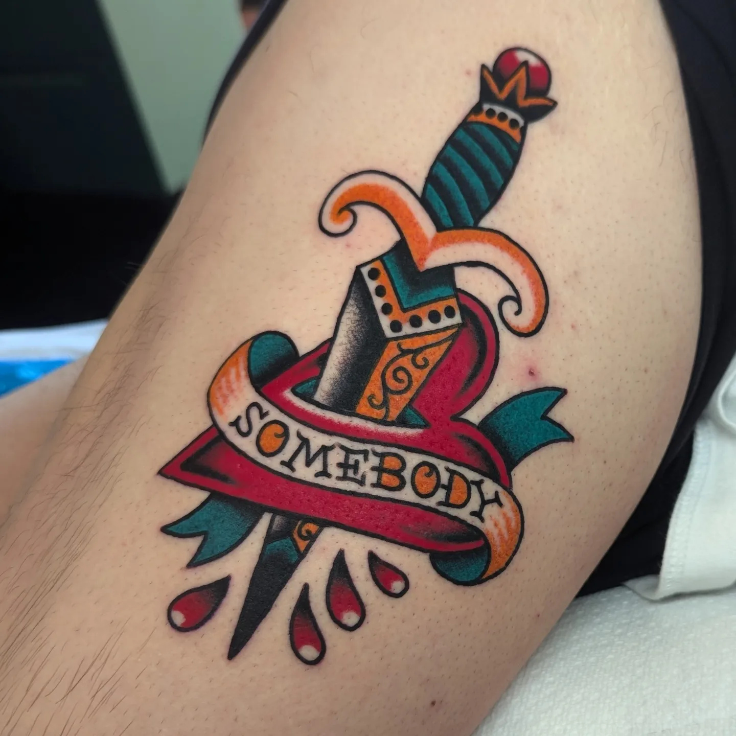 Knife and ribbon American traditional tattoo on the thigh by Zack Mueller