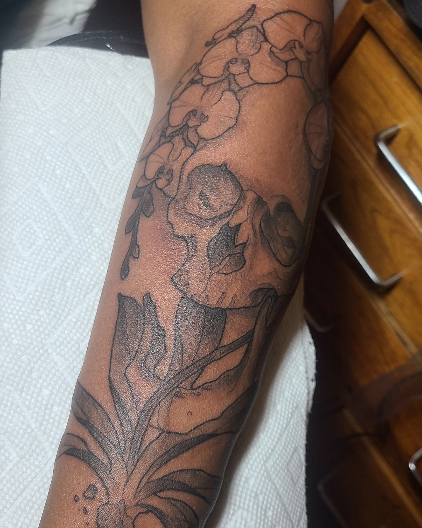 Skull and flowers black and grey tattoo on the forearm by Robert Kraiza - Philadelphia Tattoo Artist