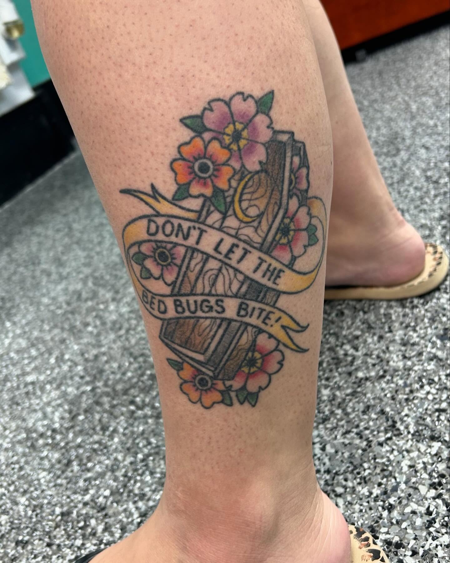 Book and flowers American traditional tattoo on the forearm by Jayda Shell