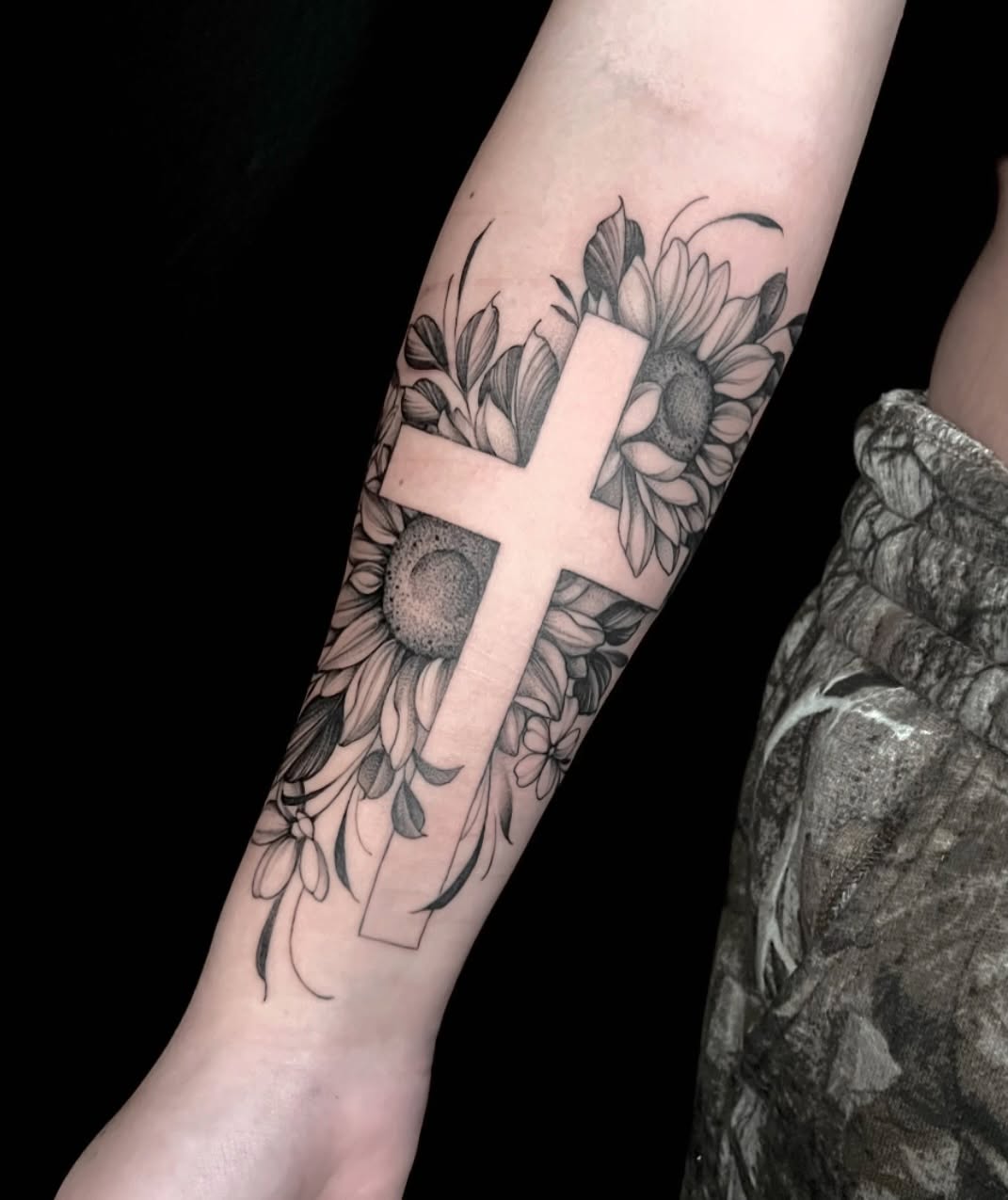 Cross with sunflowers black and grey tattoo on the forearm by Chelsea Speirs
