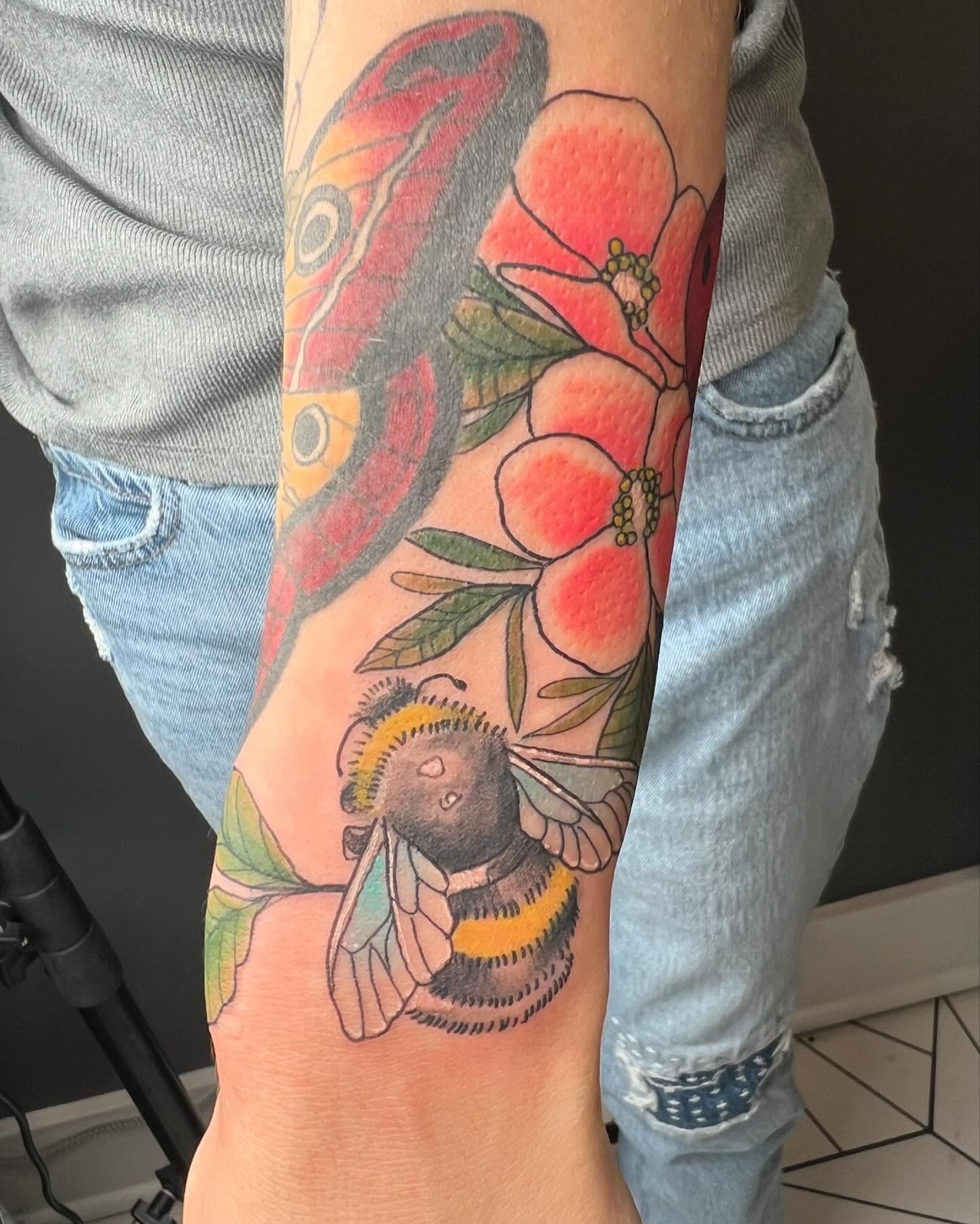 Butterfly, flowers, bee realism tattoo on the forearm by Taylor Steckman