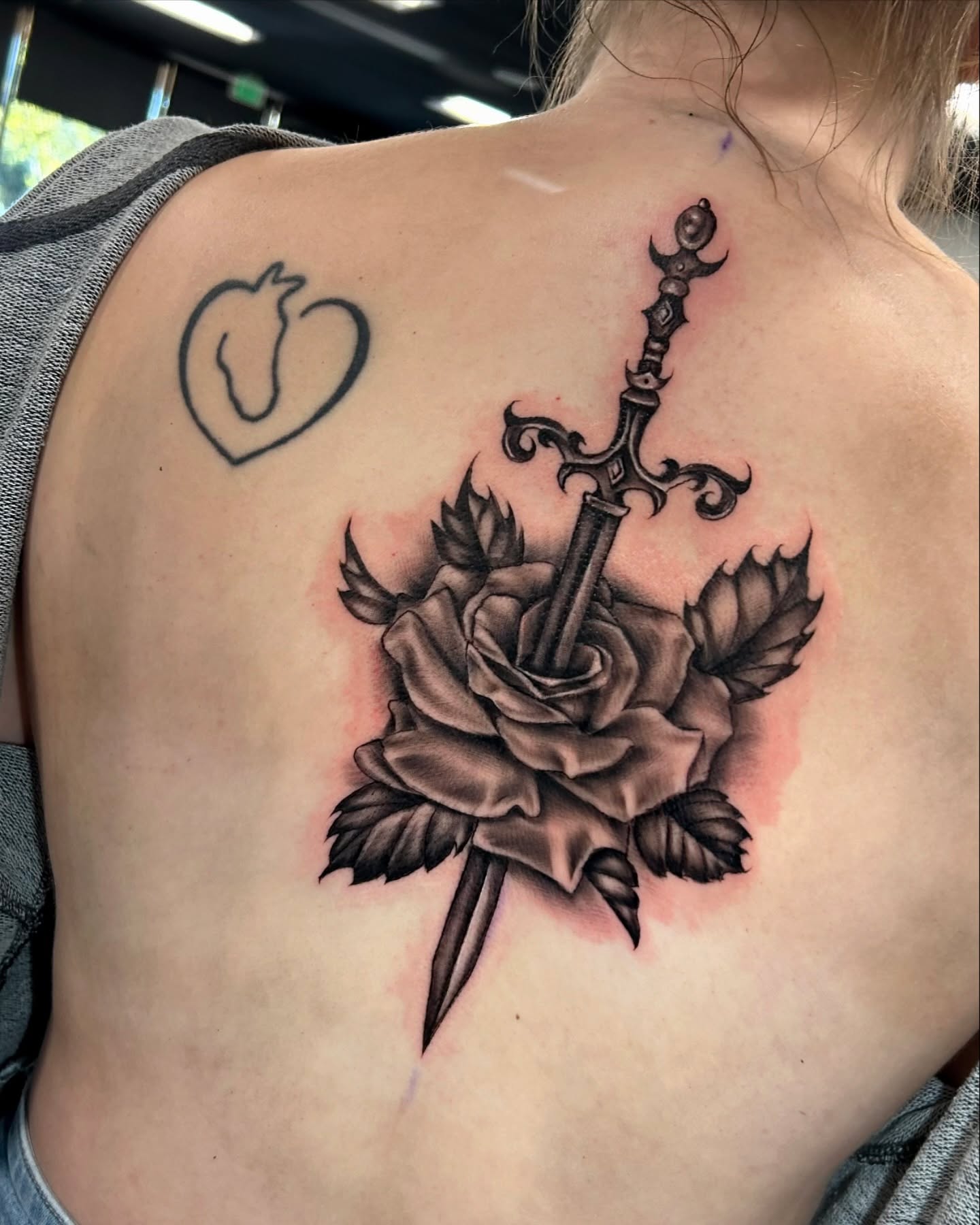 Sword through rose realism tattoo on the back by Grace P