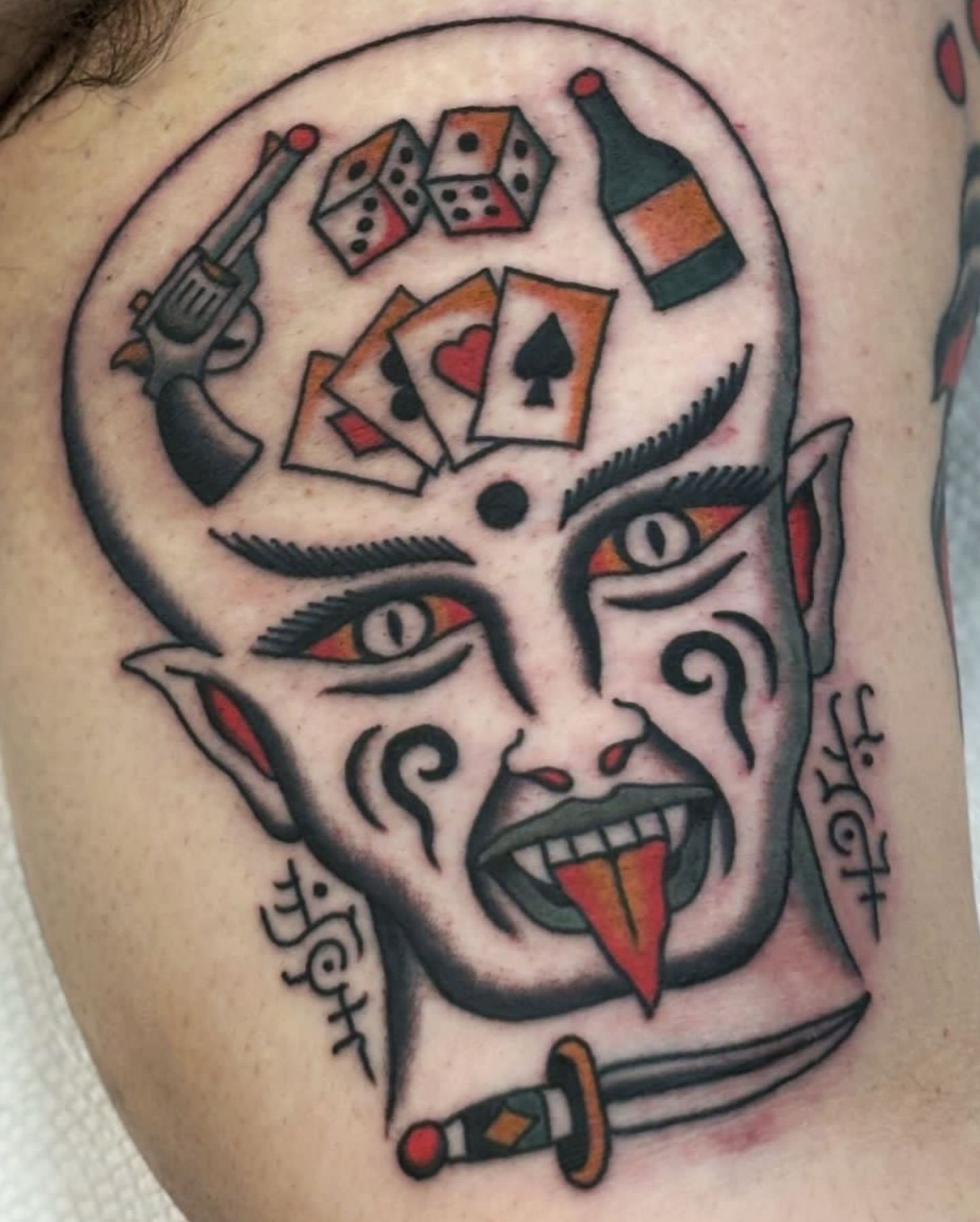 Devil face American traditional tattoo on the shoulder by Ben Fiedler