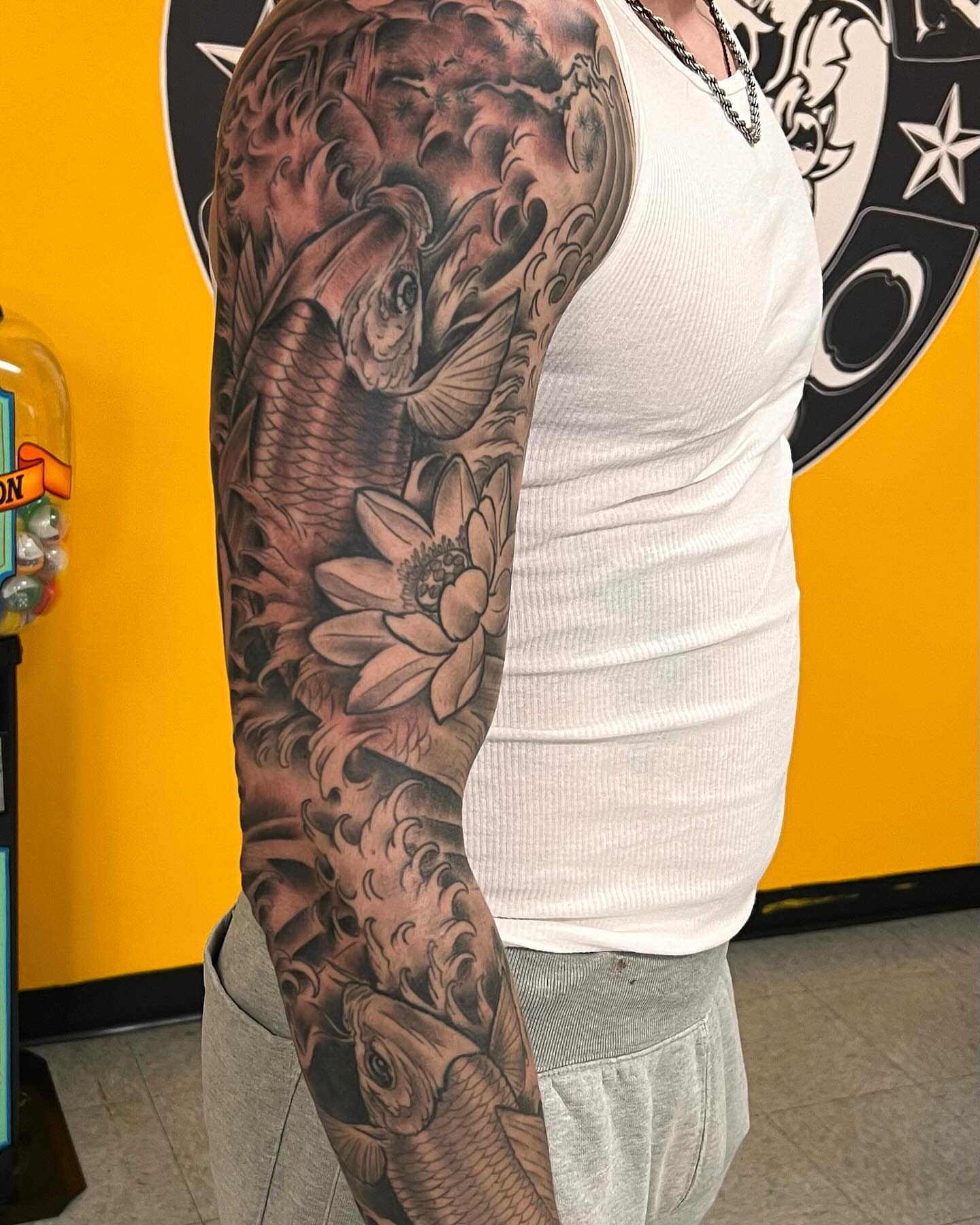 Koi fish and lotus flower realism tattoo on the upper arm by Frank Gomez 🎨