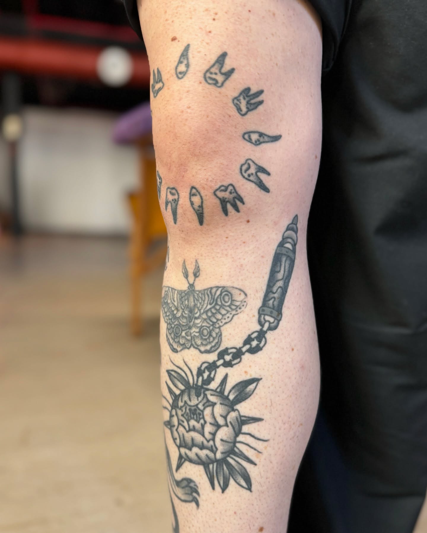 Teeth and moth black and grey tattoo on the forearm by Mazie