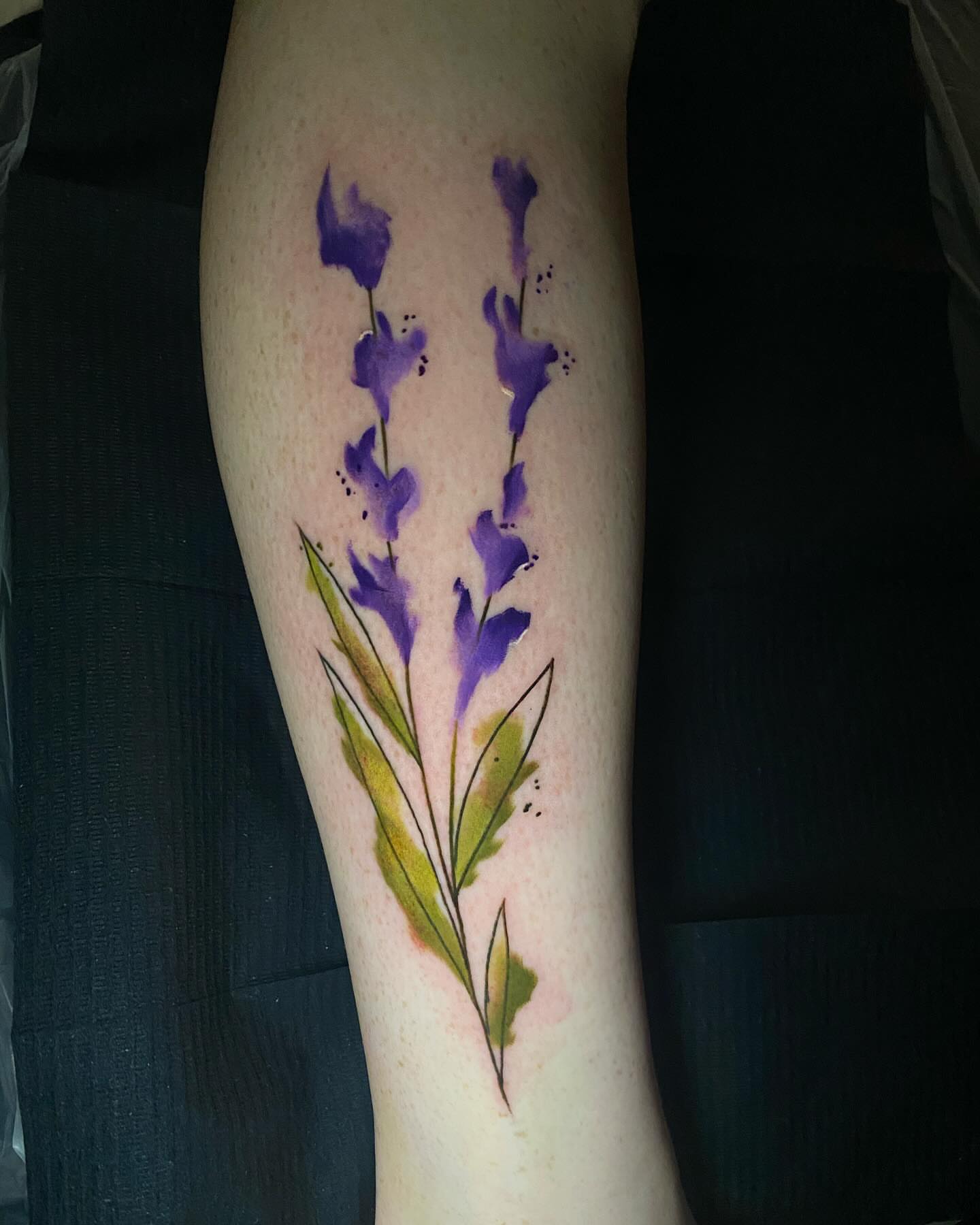 Purple flowers watercolor tattoo on the forearm by Bruce becerra tattoos