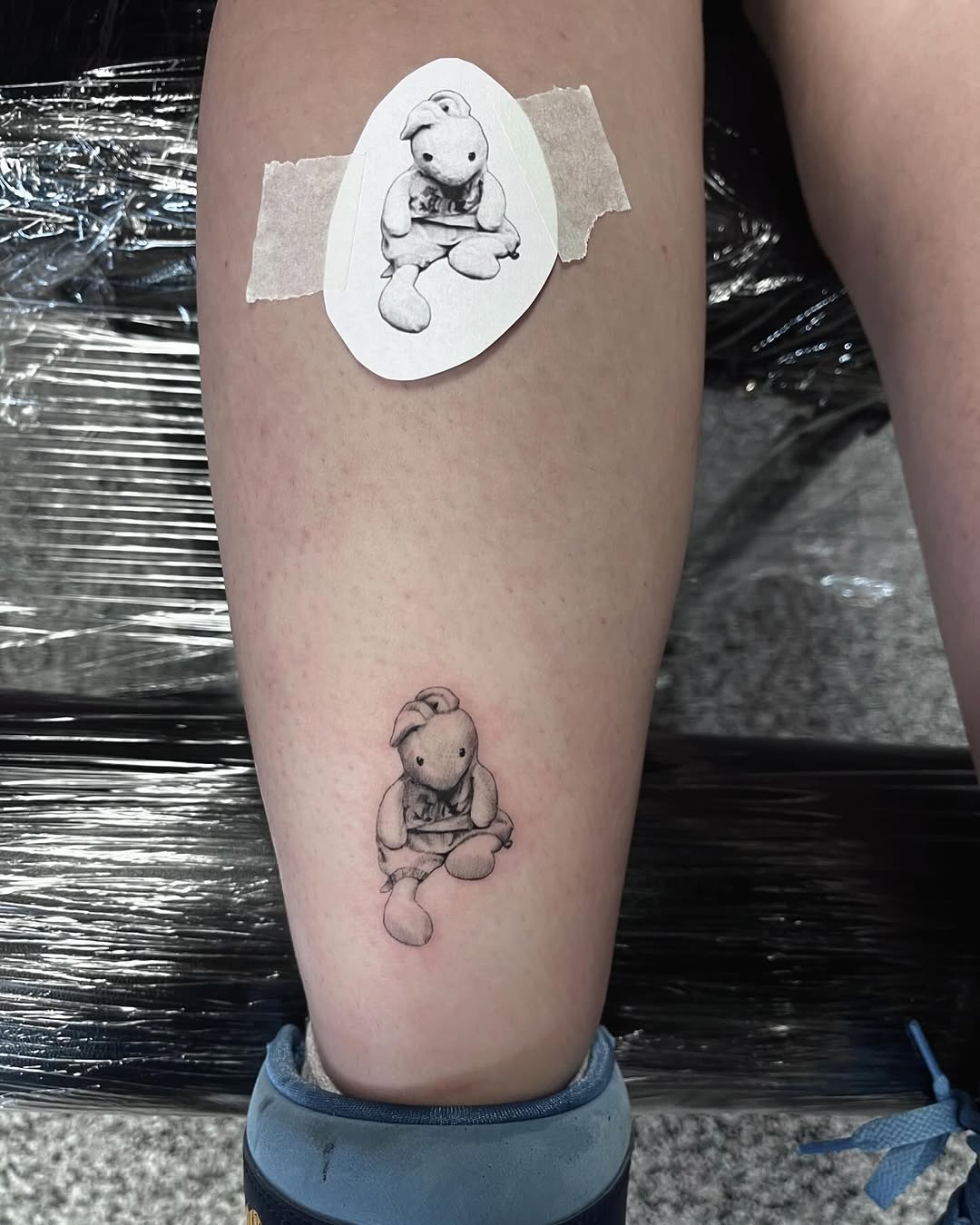Stuffed bunny minimalist tattoo on the calf by Jonathan Red